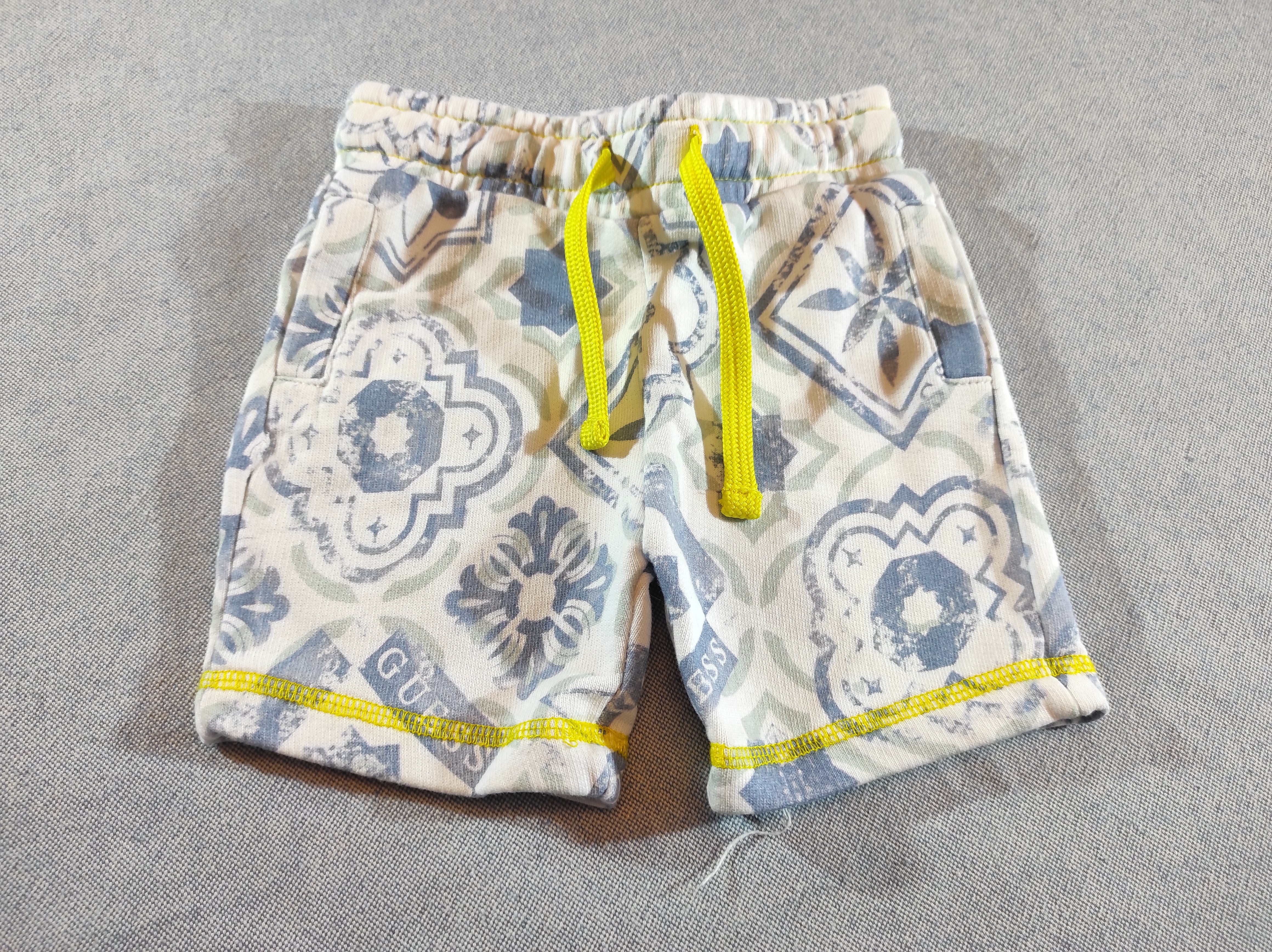 Short molleton blanc , motifs bleus , cordon jaune
