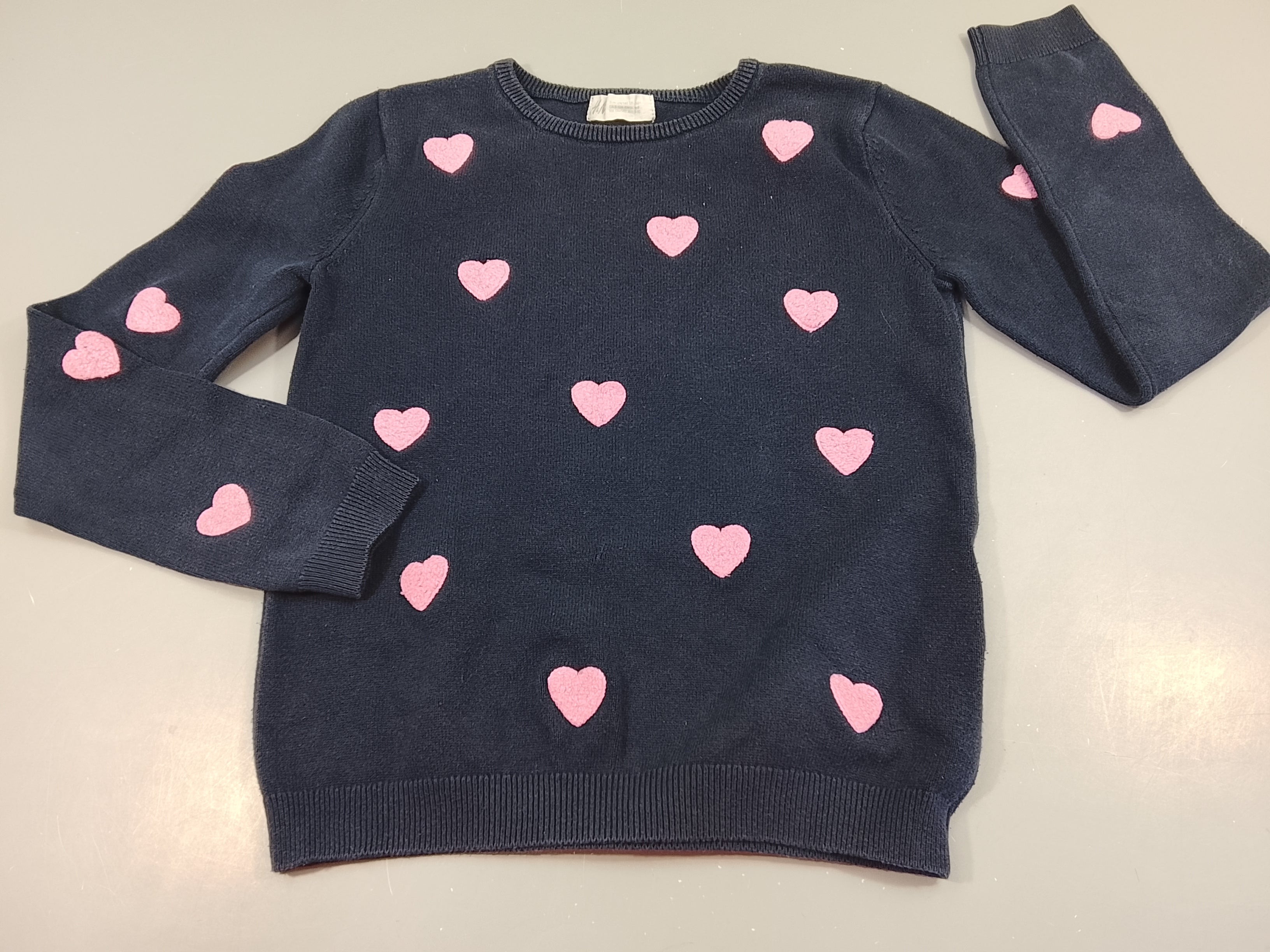 Pull bleu marine, coeurs texturés roses, très légèrement bouloché