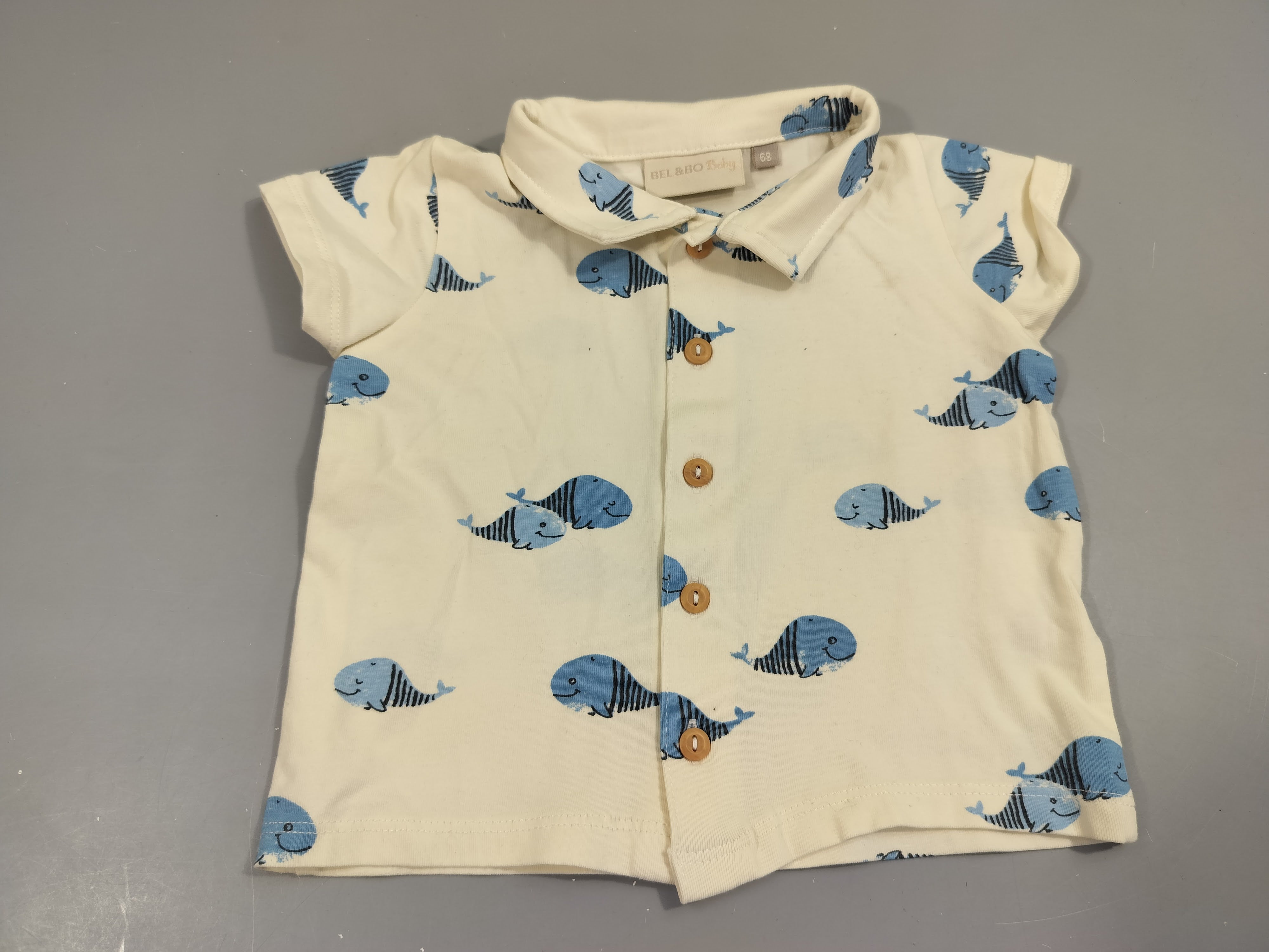 Polo m.c jersey  boutonné beige clair motifs poissons, petite tache sur le dessus  95% coton 5% élasthanne