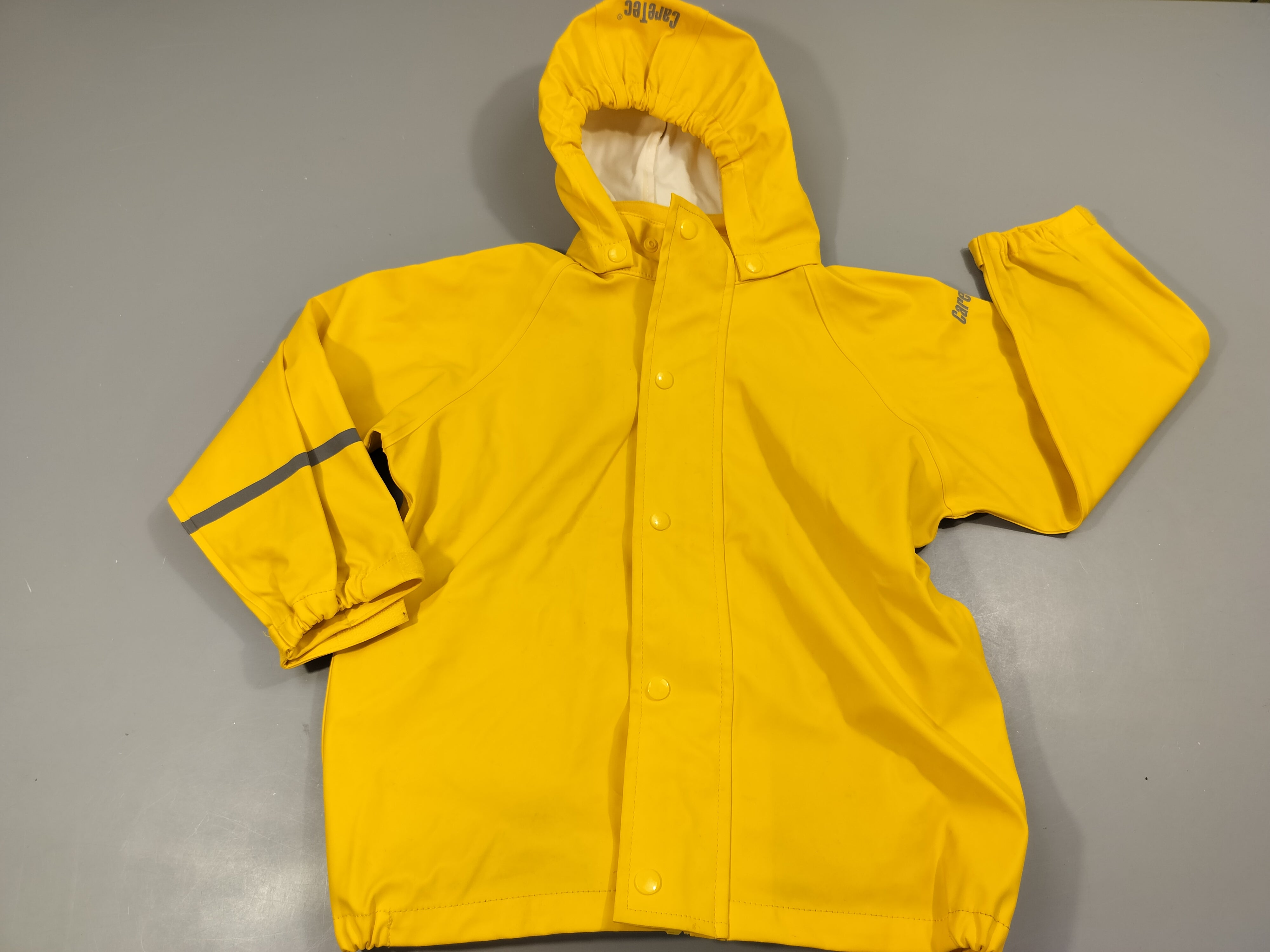 Ciré jaune à capuche , taché à l'arrière