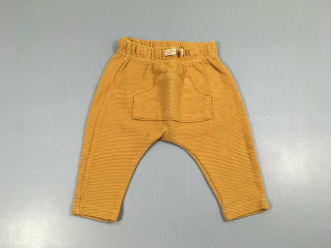 Pantalon molleton texturé orange, un peu bouloché, moins cher chez Petit Kiwi