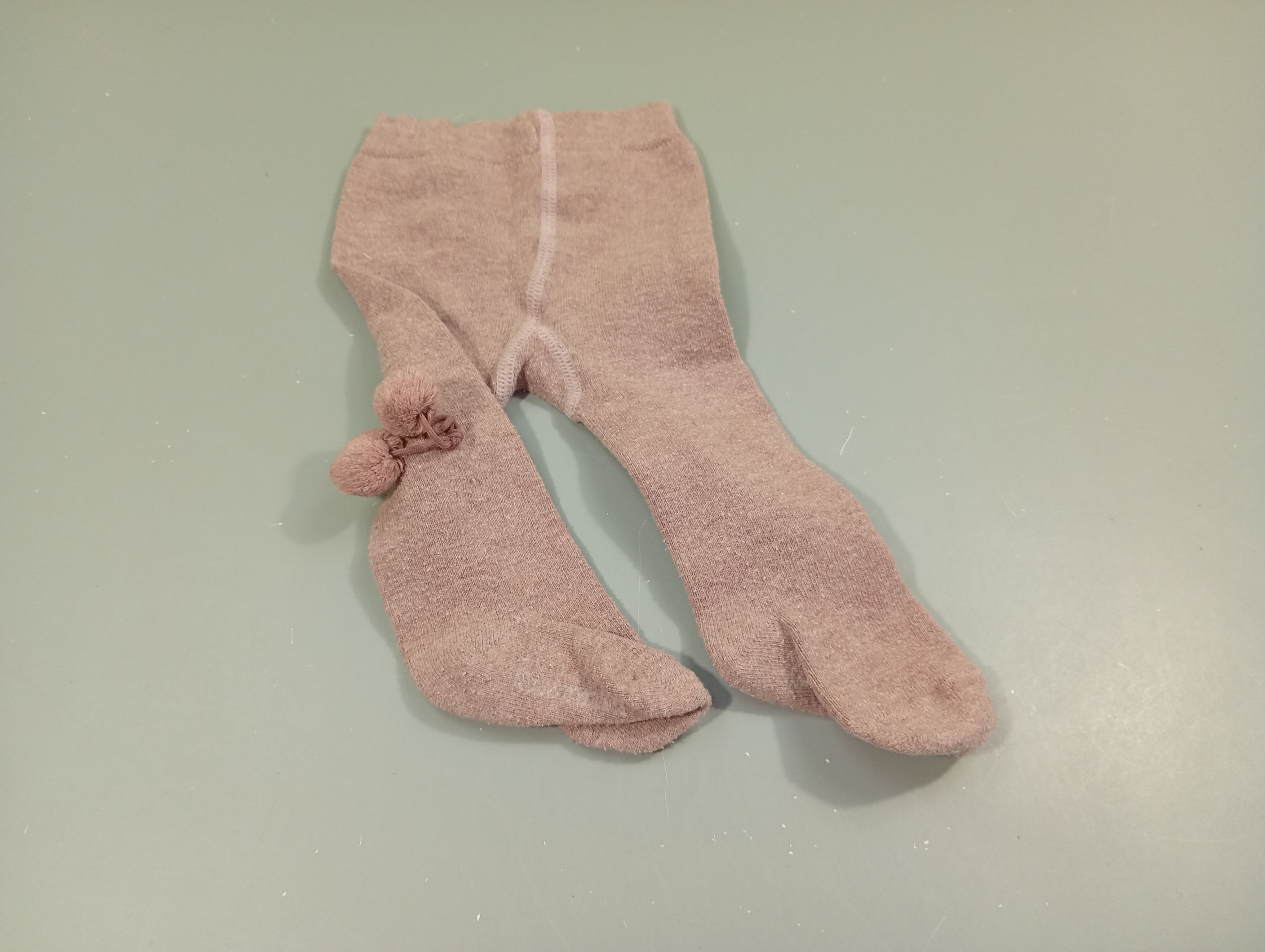 Collants mauve clair, pompons à l'arrière. Un peu bouloché