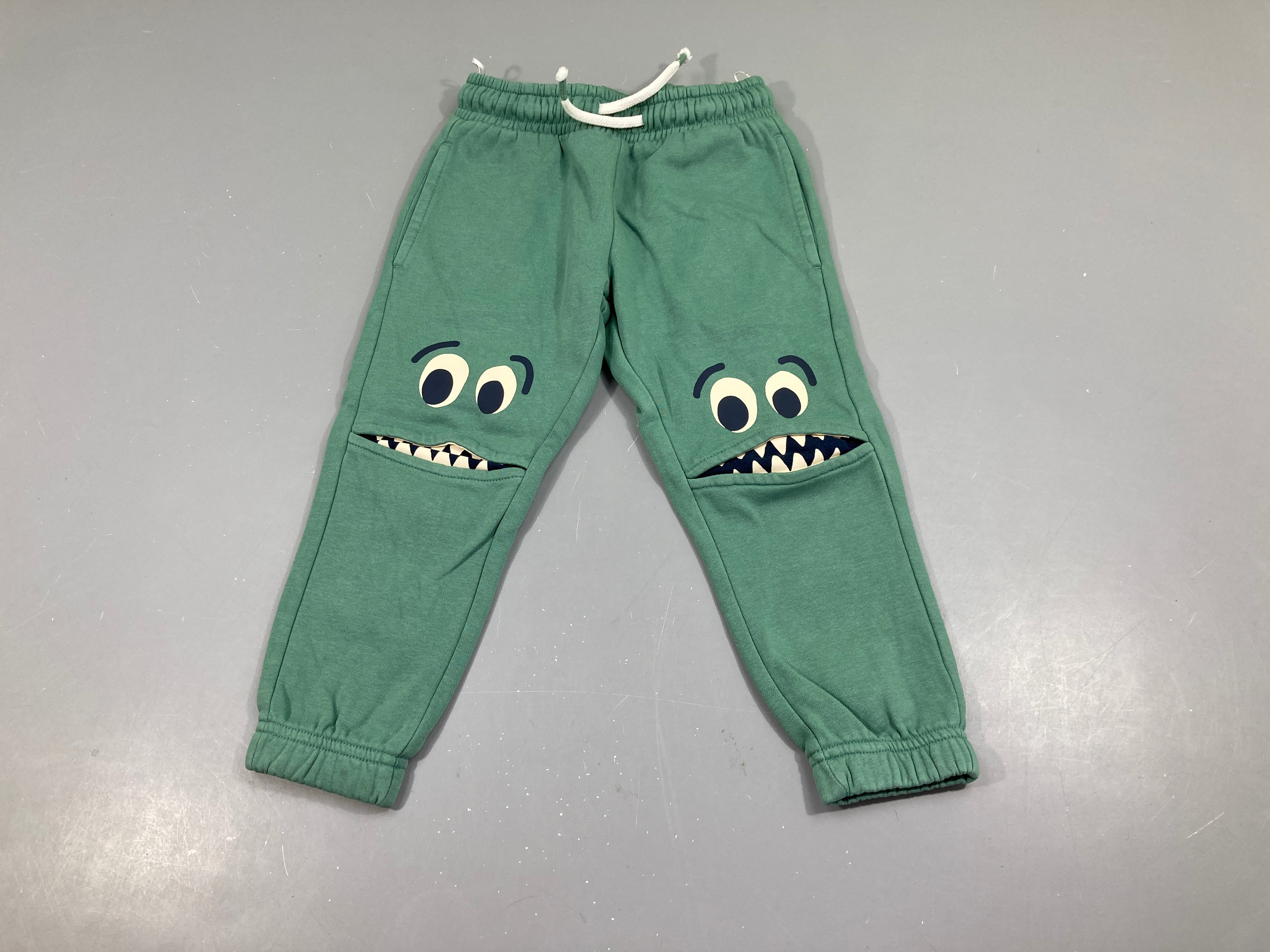 Pantalon de training vert visages genoux