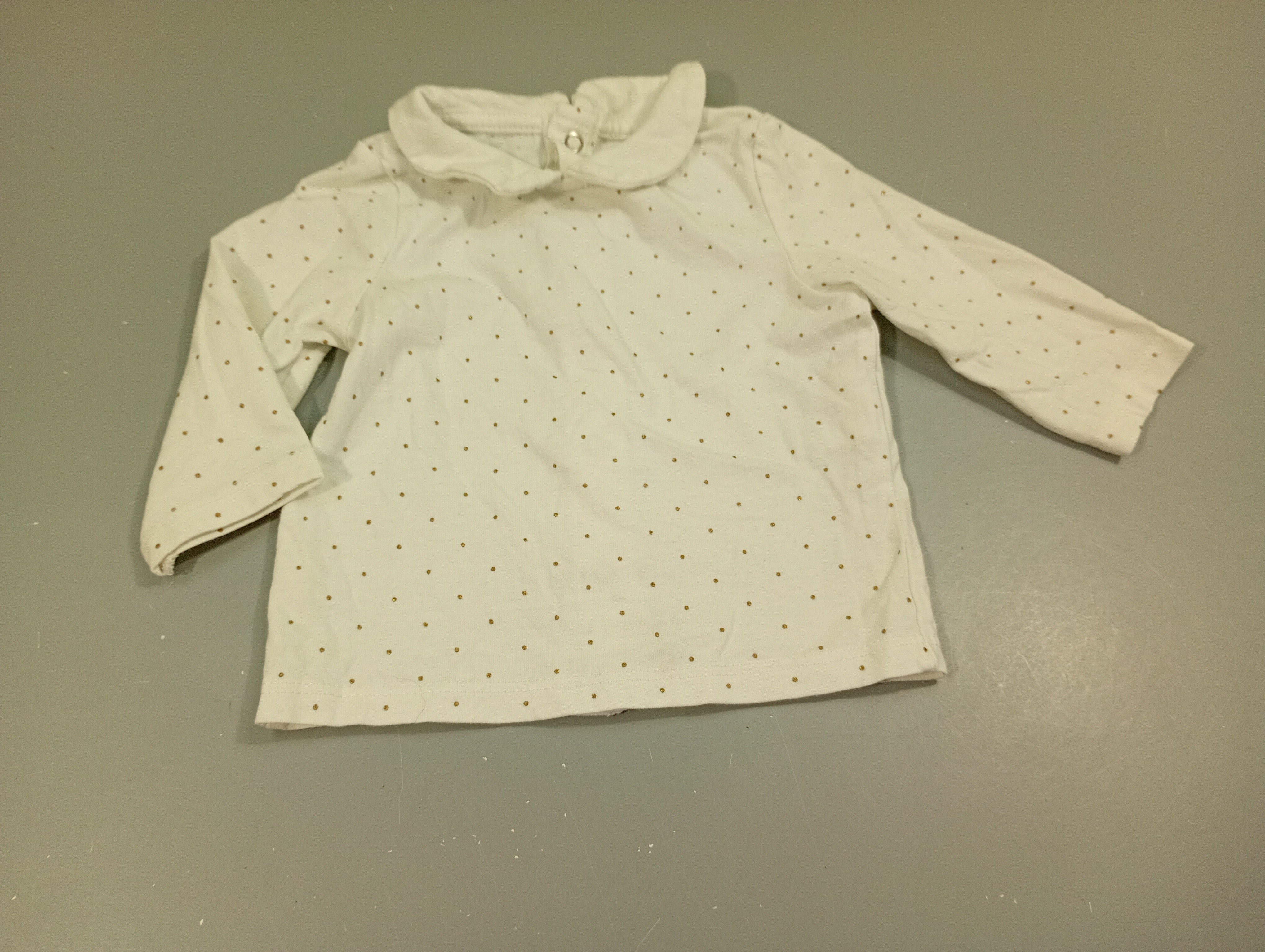 T-shirt m.l blanc à pois argenté, petit col. Fermeture par pressions à l'arrière