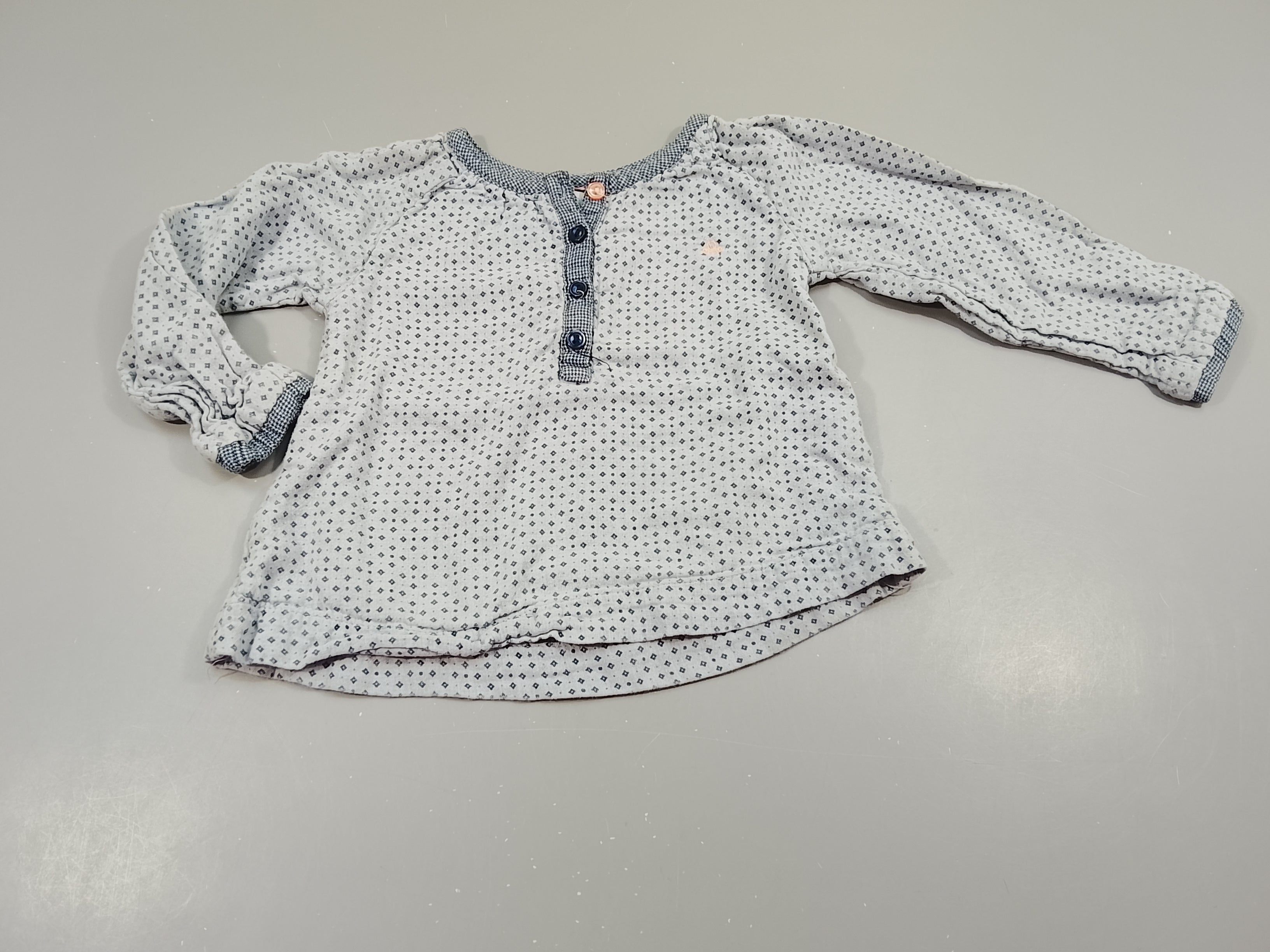 Blouse ml bleue à motifs. Boutons bleu marine, rose