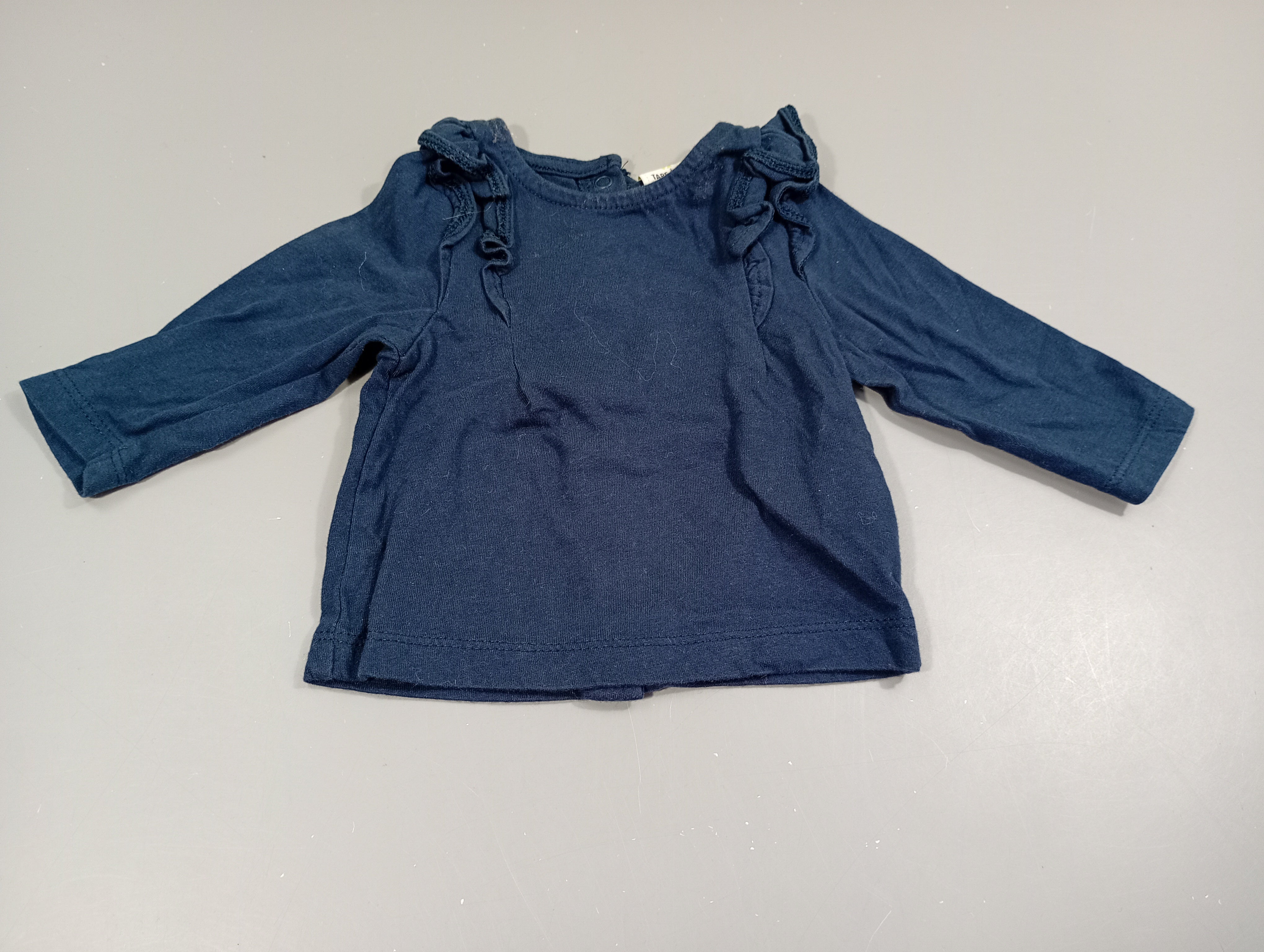 T-shirt m.l bleu marine , volants  aux manches , fermeture par pressions à l'arrière