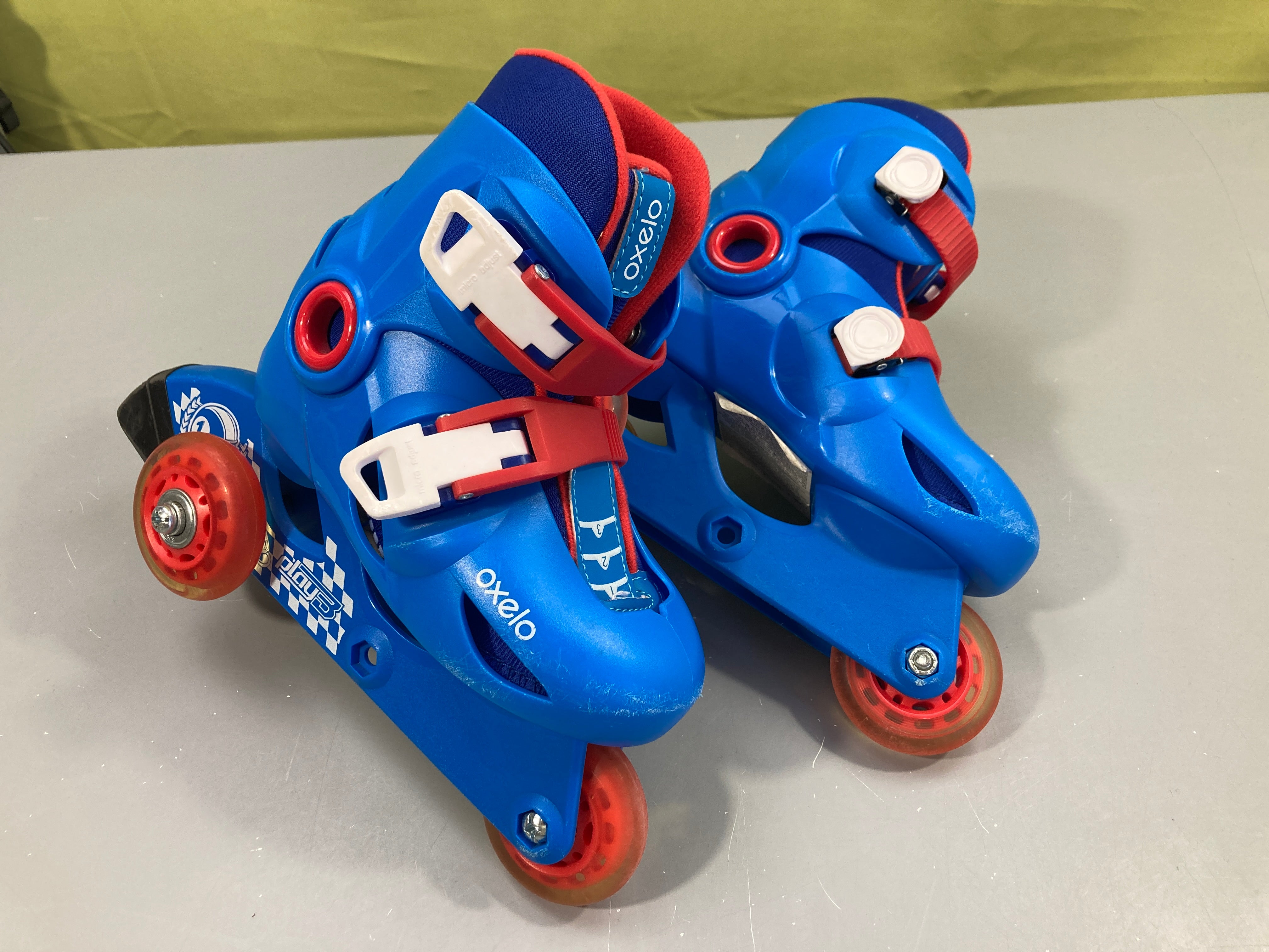 Rollers bleu-rouge Oxelo Play 3 26-28 avec roues installées en tricycles pour plus de stabilité. Se modifie en posistion 3 roues.