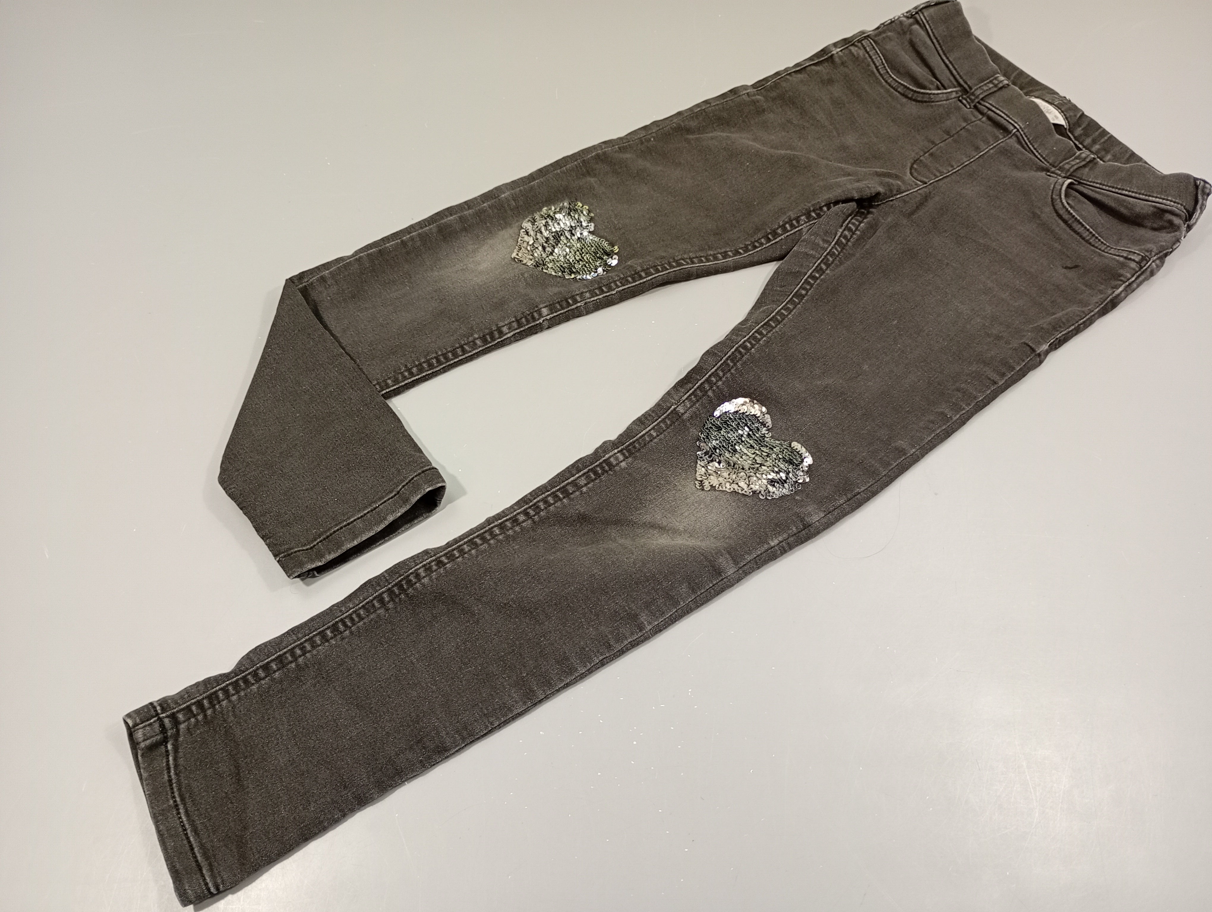 Jegging, denim noir, coeurs en sequins réversibles aux genoux petit accroc dessous de la poche et légères usures aux genoux