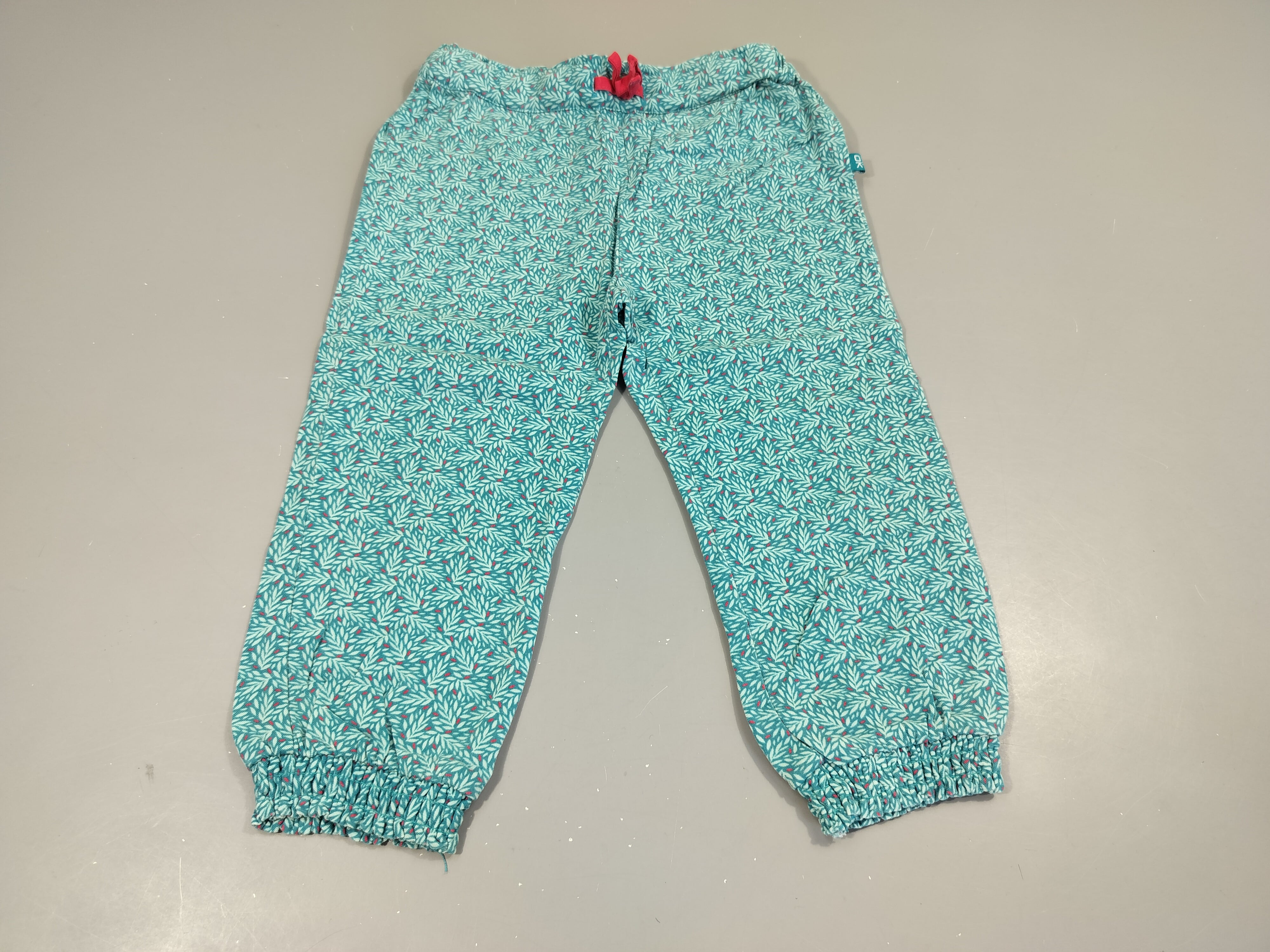 Pantalon fluide bleu à motifs. noeud rose