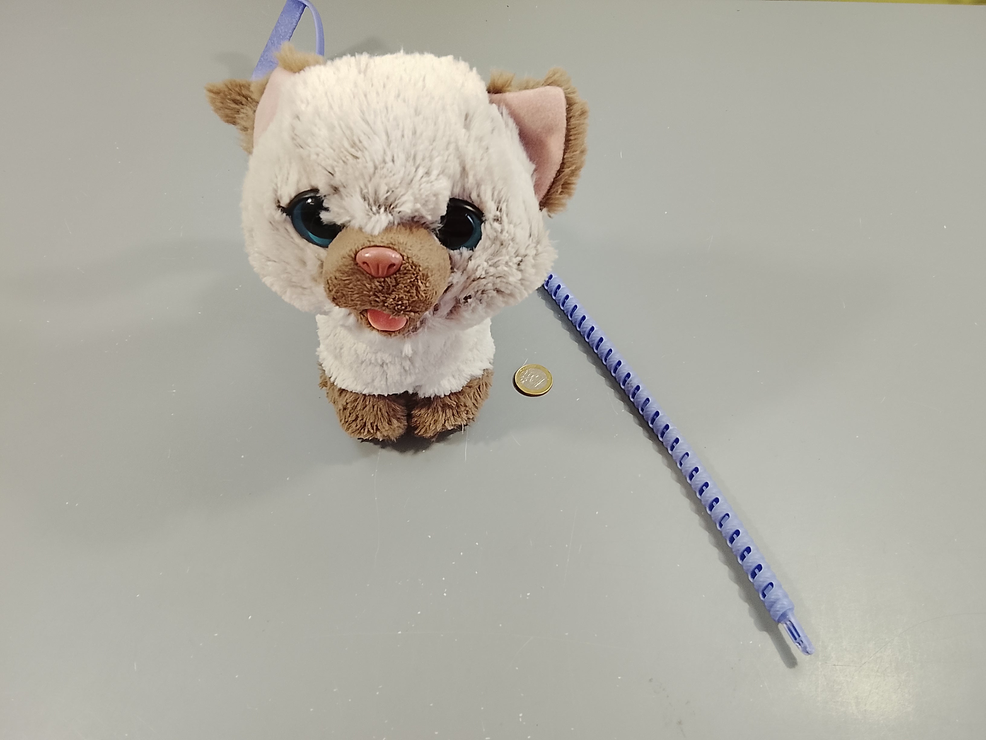 Peluche interactive  chaton gris qui fait ses besoins.+ laisse. Friandises coincées à l'intérieur, ne sortent plus. Le son fontionne.