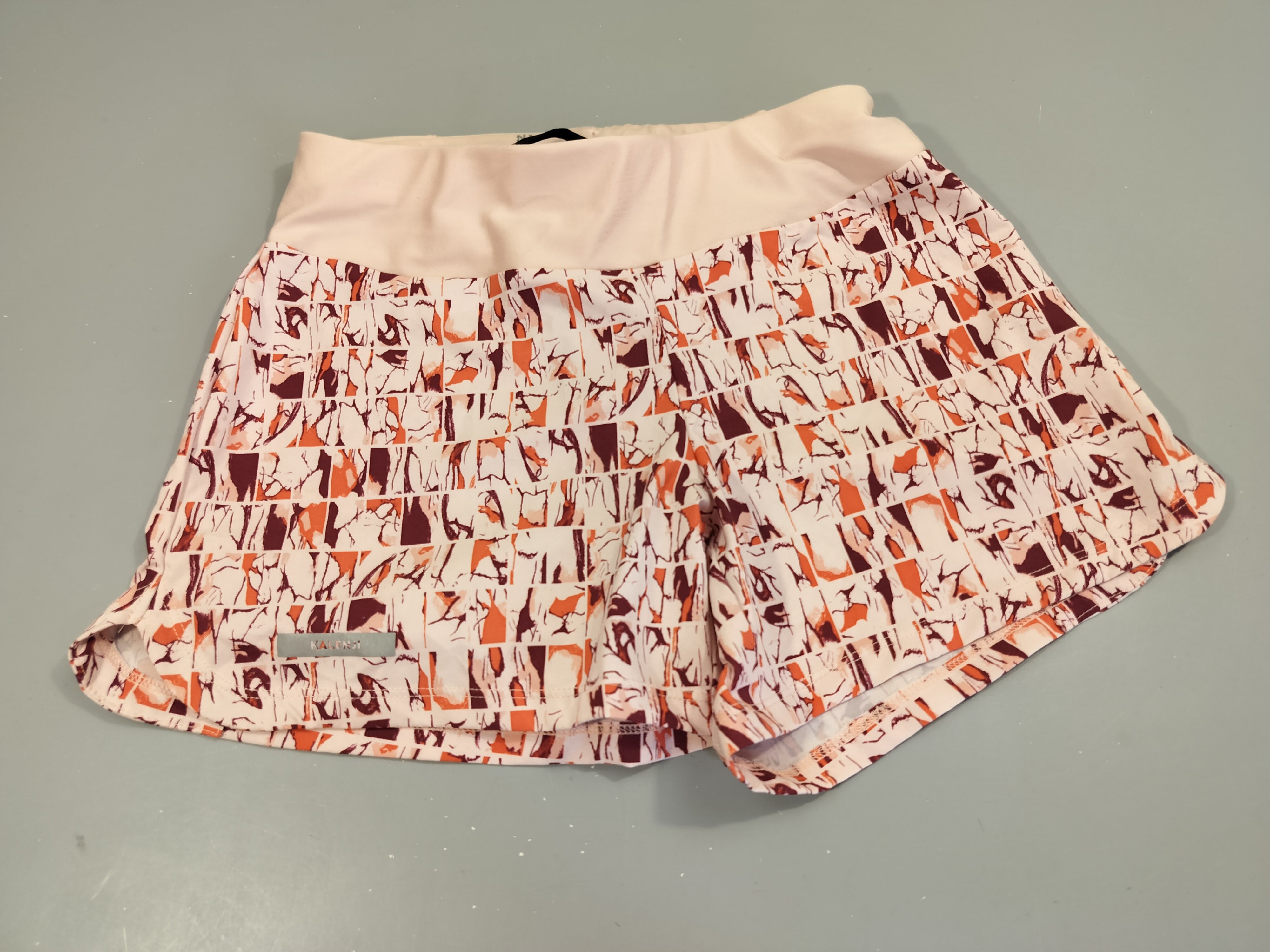 Short de sport  rose pâle à motifs imprimés. Pas de taille indiquée, estimée 11a