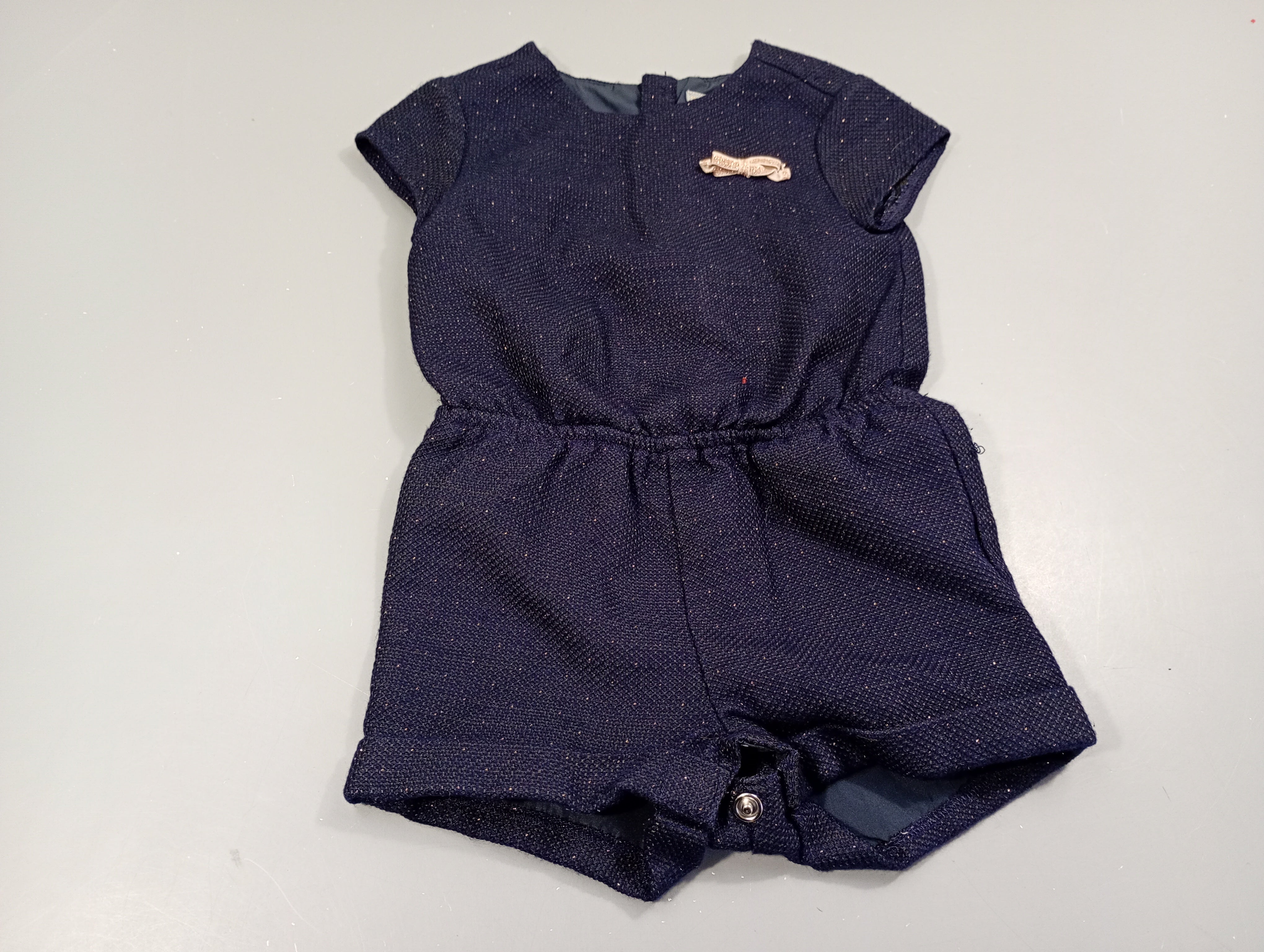 Combishort m.c bleu marine texturé, fines paillettes dorées. Petit noeud doré