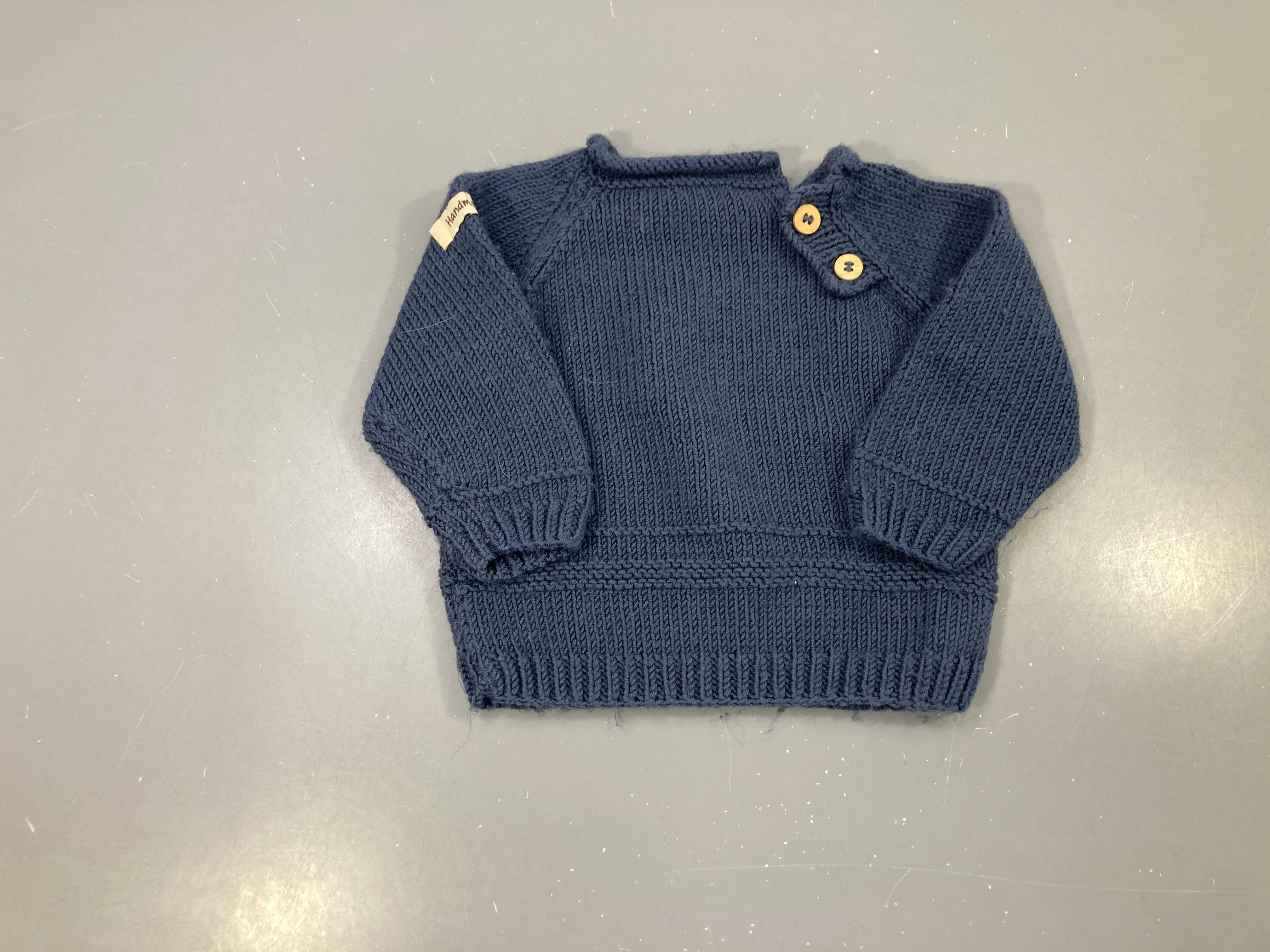 Pull tricot main bleu marine, col boutonné 2 boutons bois à l'épaule, bord côtes