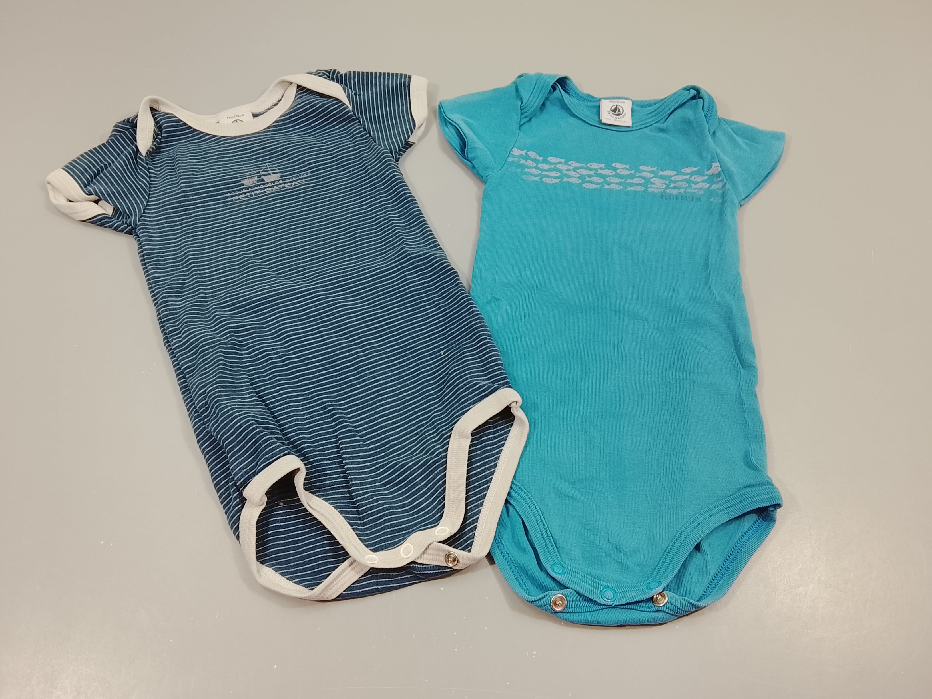 Lot de 2 bodies m.c  1 bleu marine rayé blanc et 1 bleu motifs poissons gris