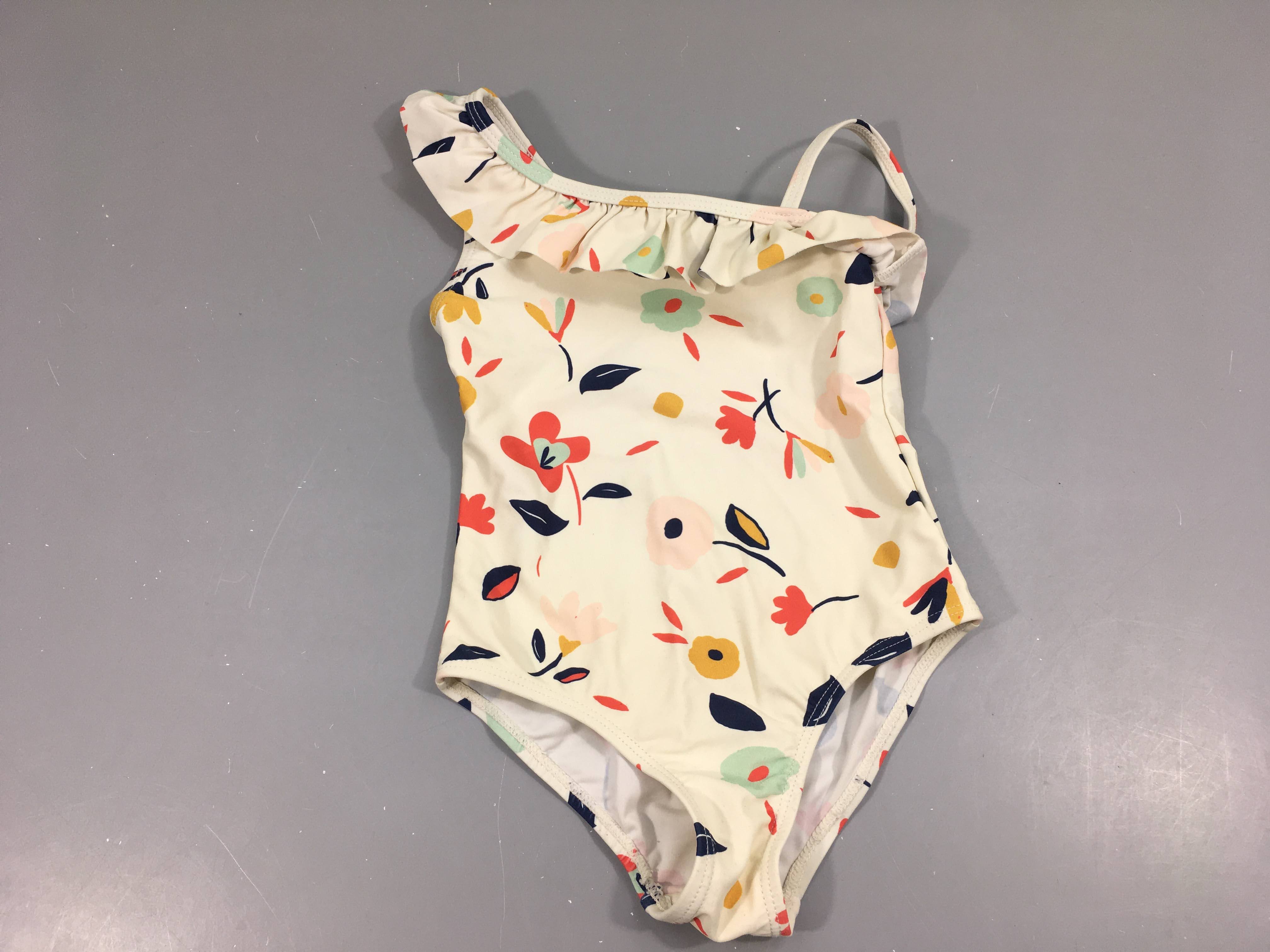 Maillot blanc fleuri volant sur une épaule