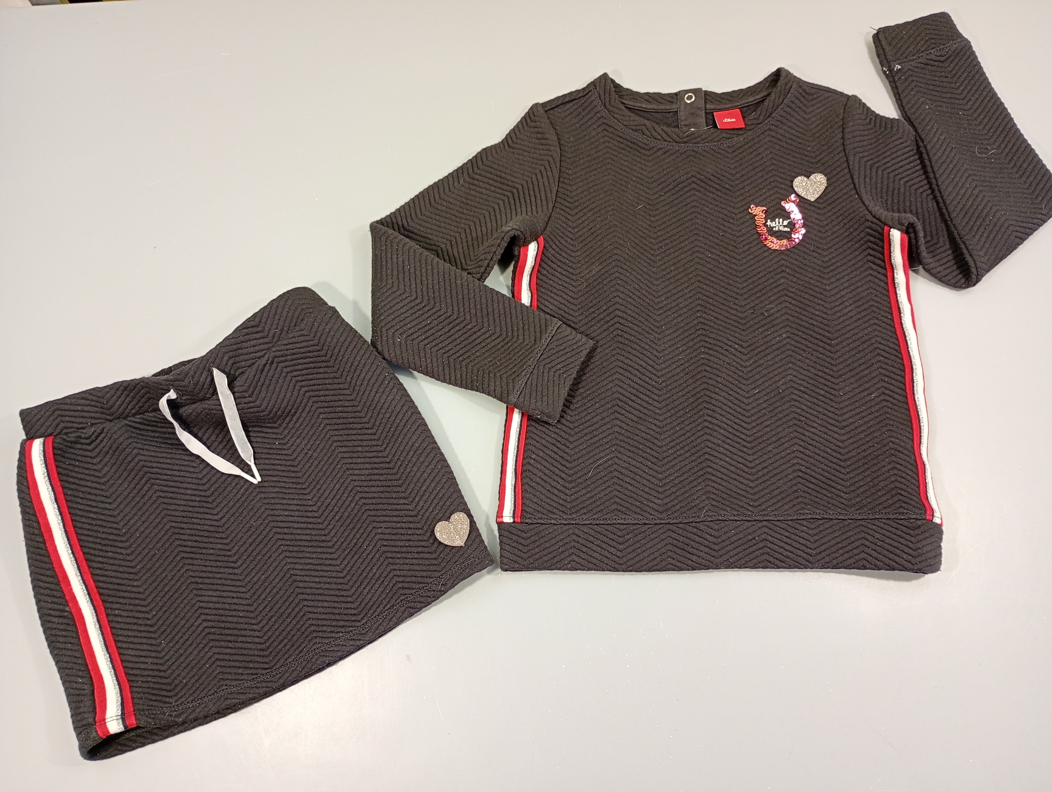 Ensemble pull bleu marine texturé bandes rouge, blanc ,pailleté , Coeur argenté pailleté +jupe assortie. Légèrement bouloché , taches blanches à la manche gauche