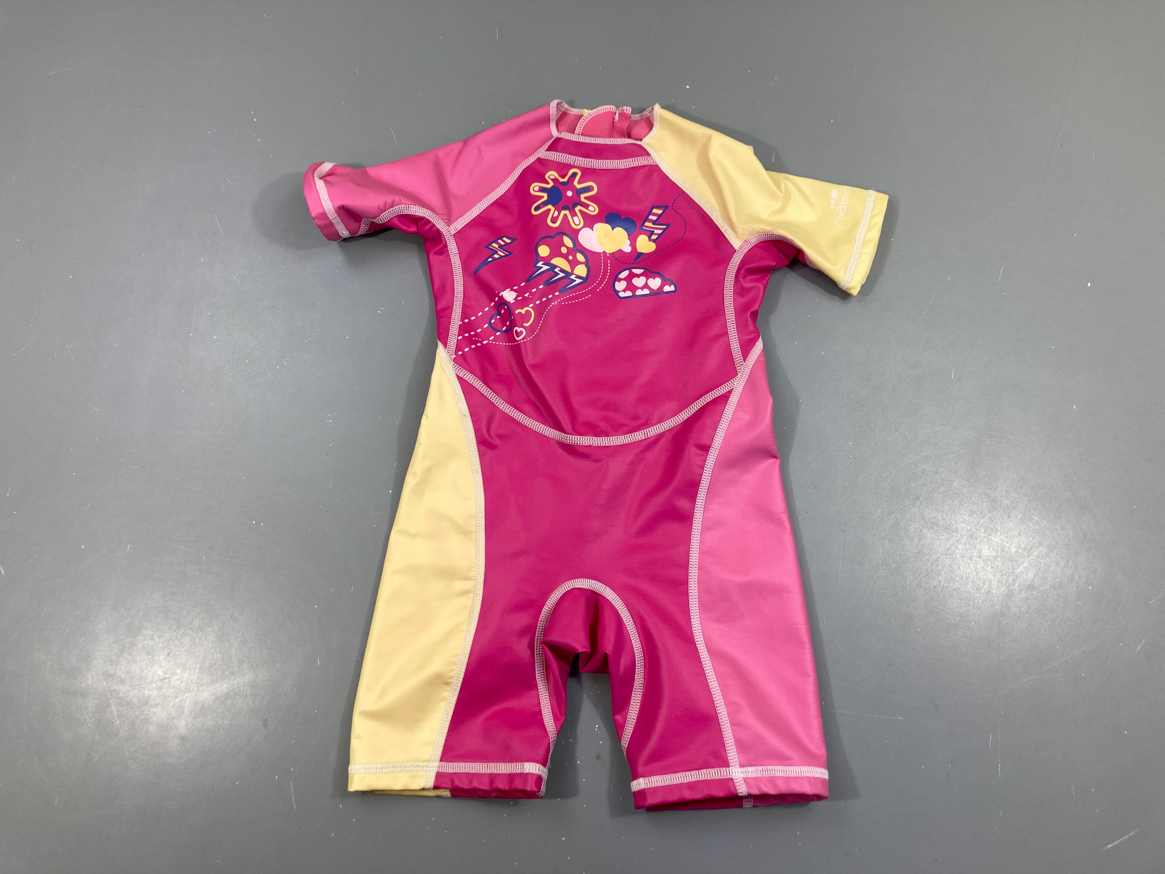 Combinaison néoprène rose-jaune légèrement craquelé sous aisselles