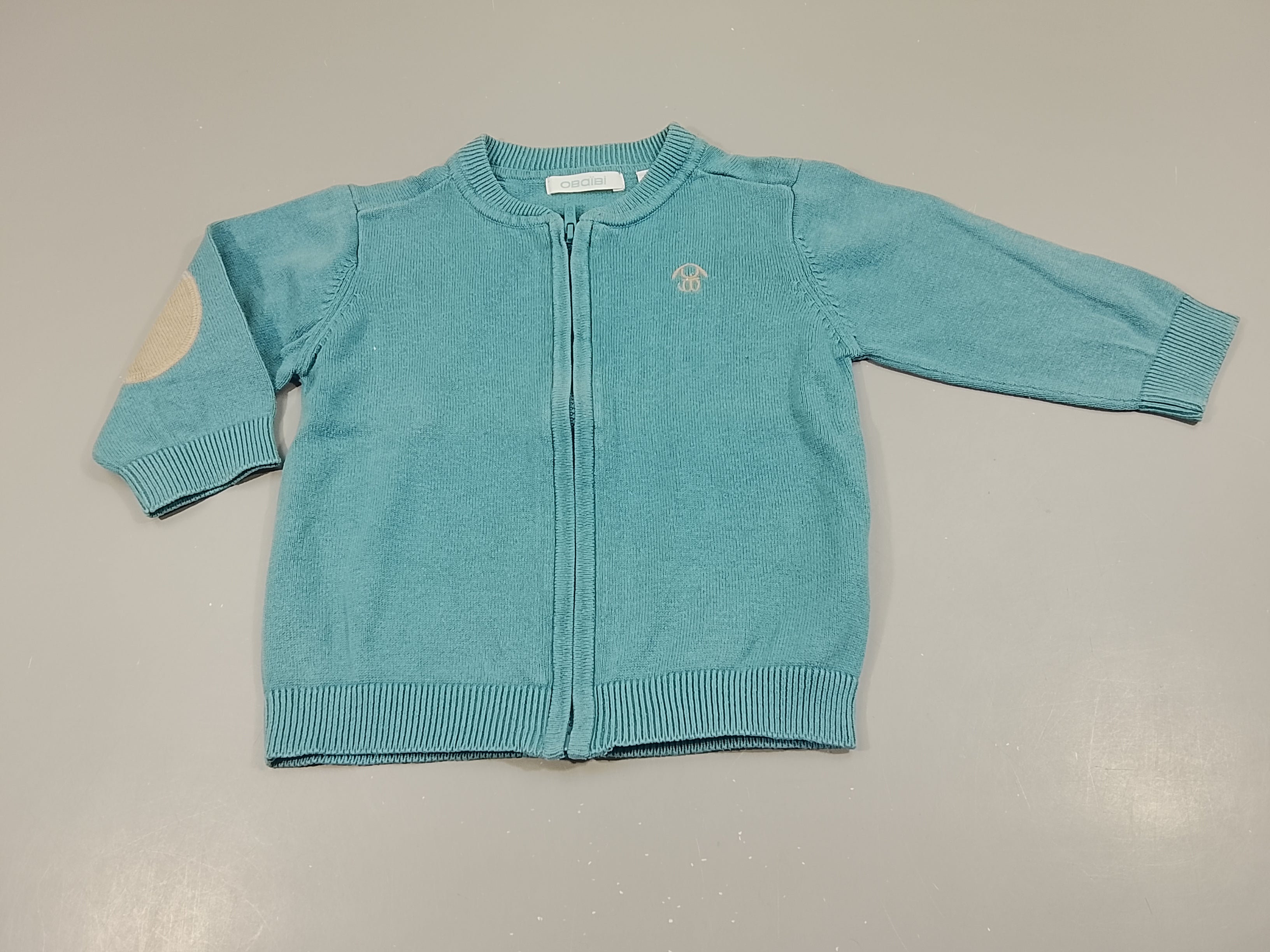 Gilet  bleu zippé, petit lapin beige. Empiècement aux coudes beiges.Très légèrement boulochés