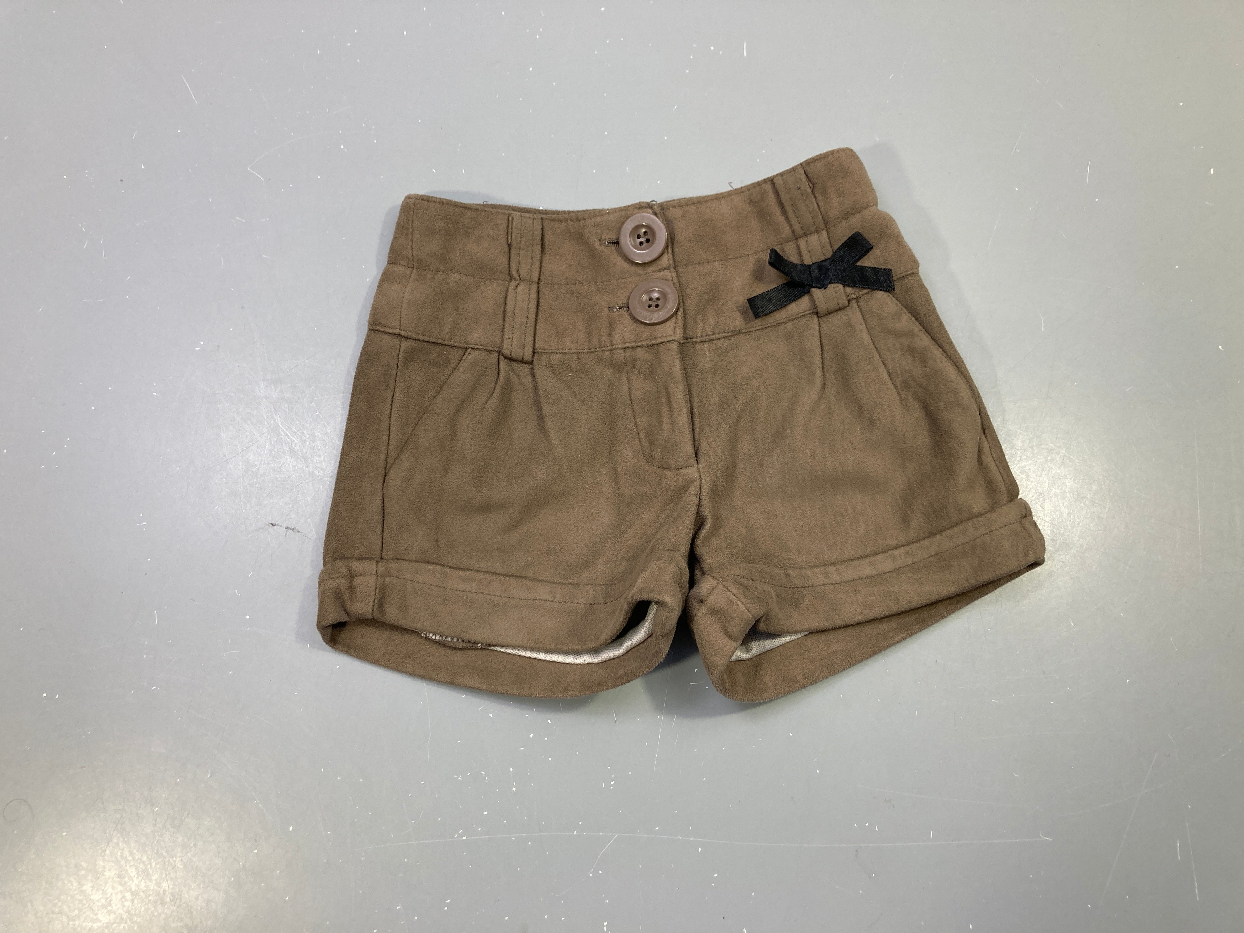 Short taupe effet daim, taille haute 2 boutons, nœud noir, revers
