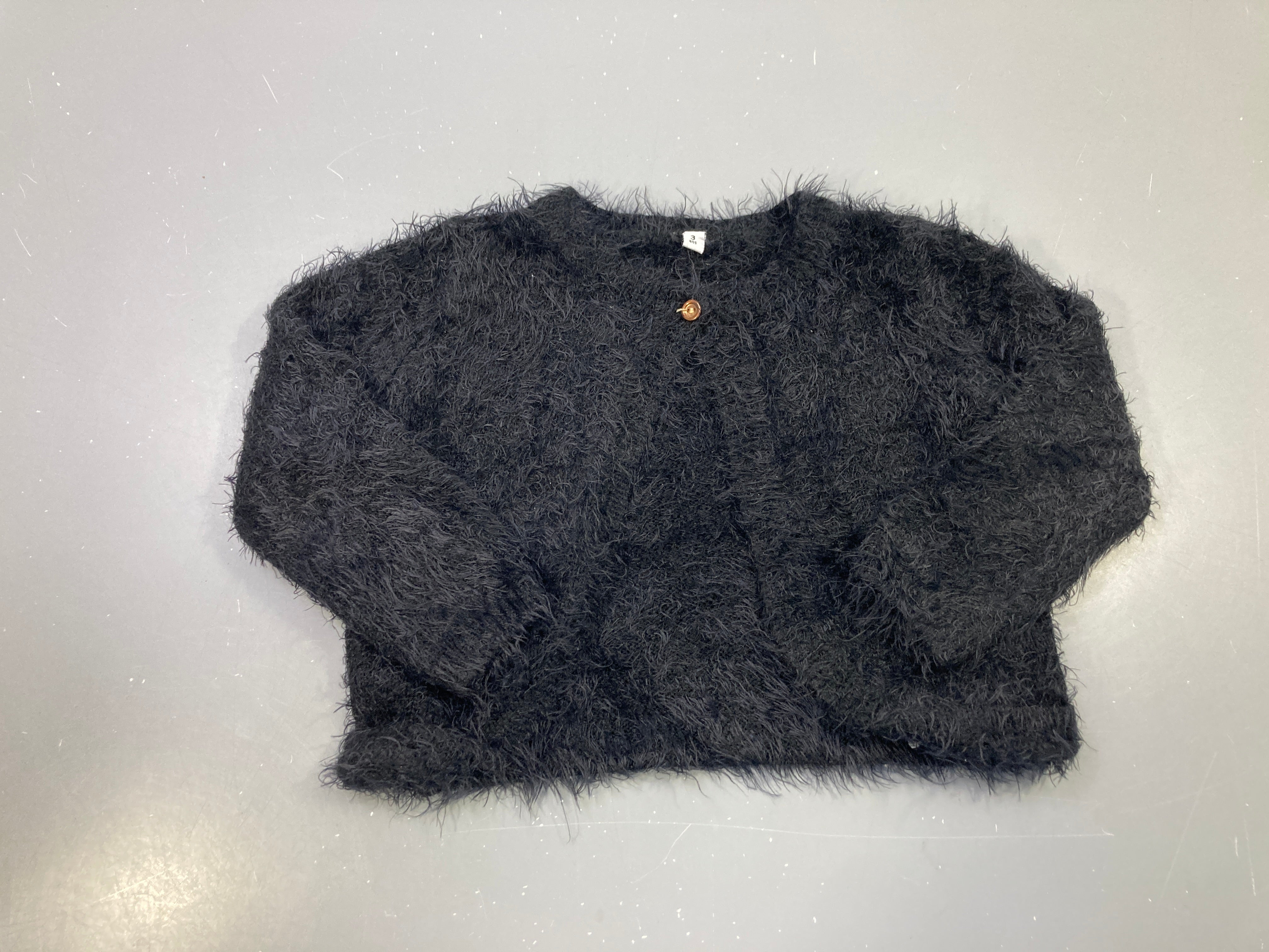 Gilet noir duveteux, bouton doré