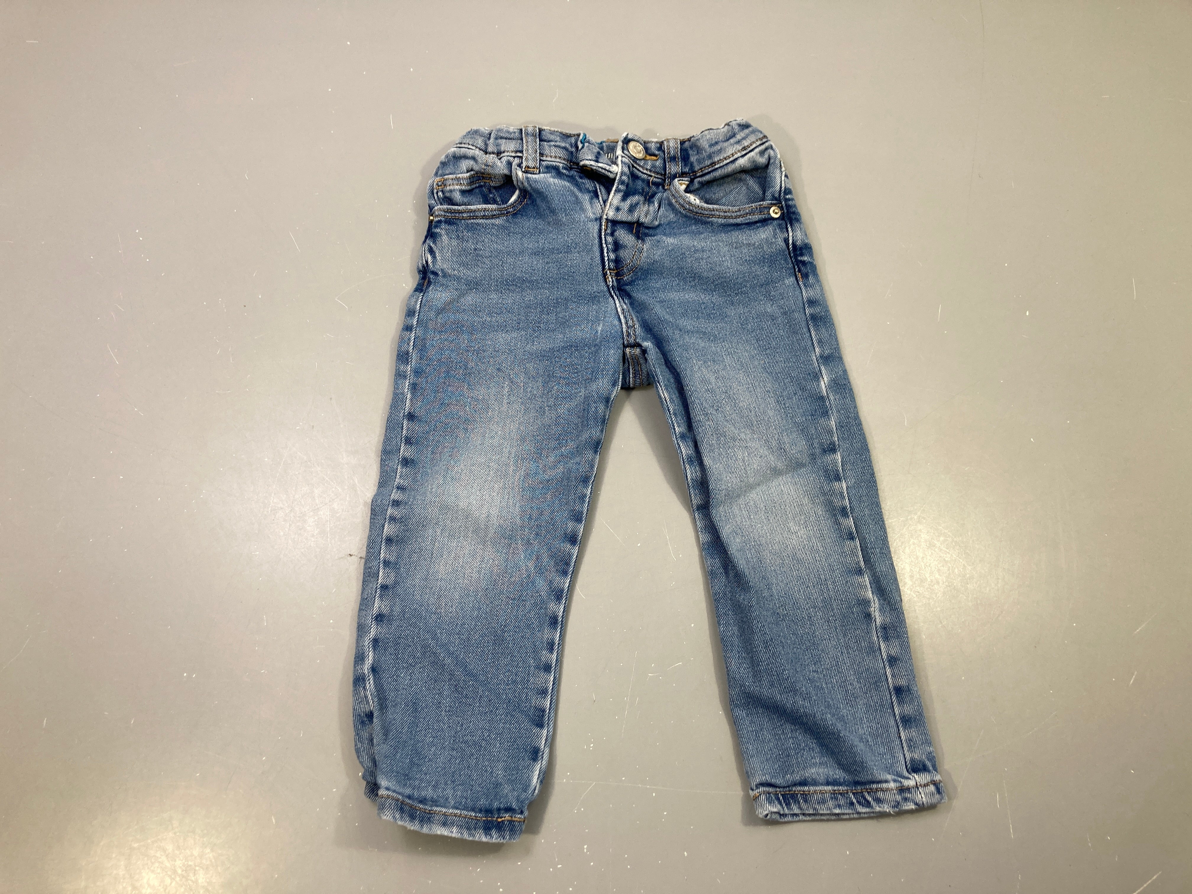Pantalon jean bleu délavé, taille réglable, étiquette arrière abîmée
