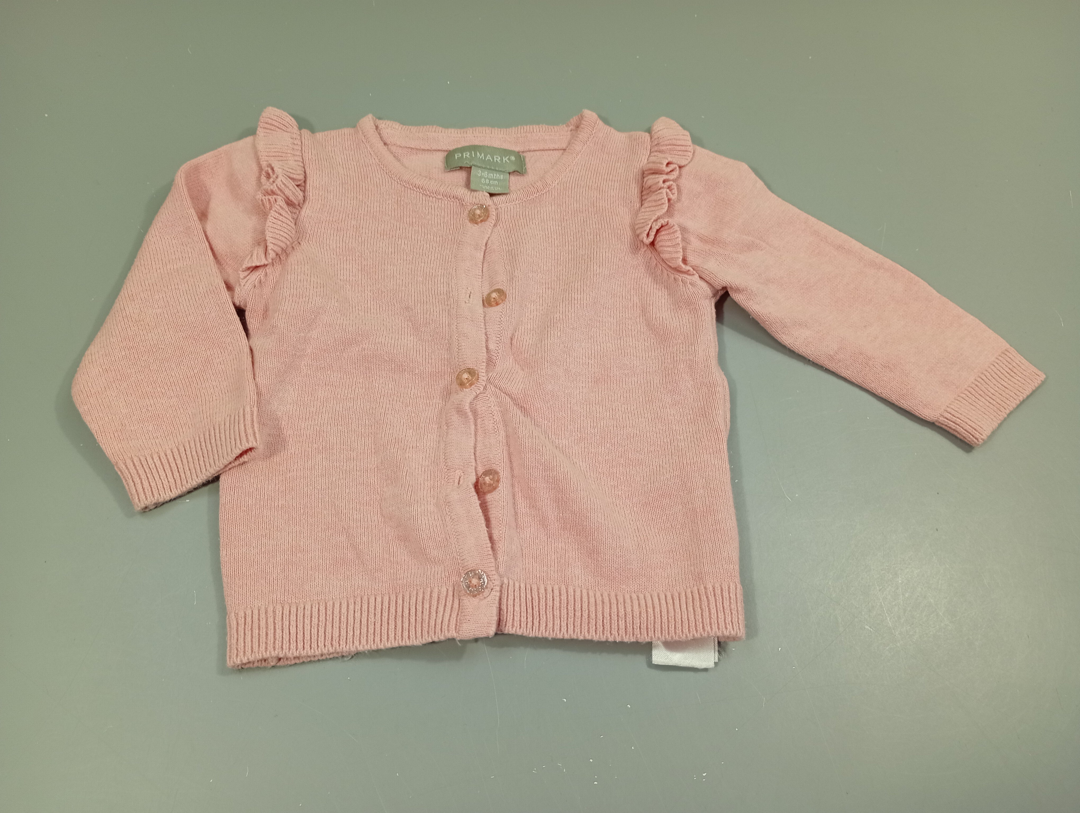 Gilet rose clair volants aux manches, boutons pailletés. Légèrement bouloché