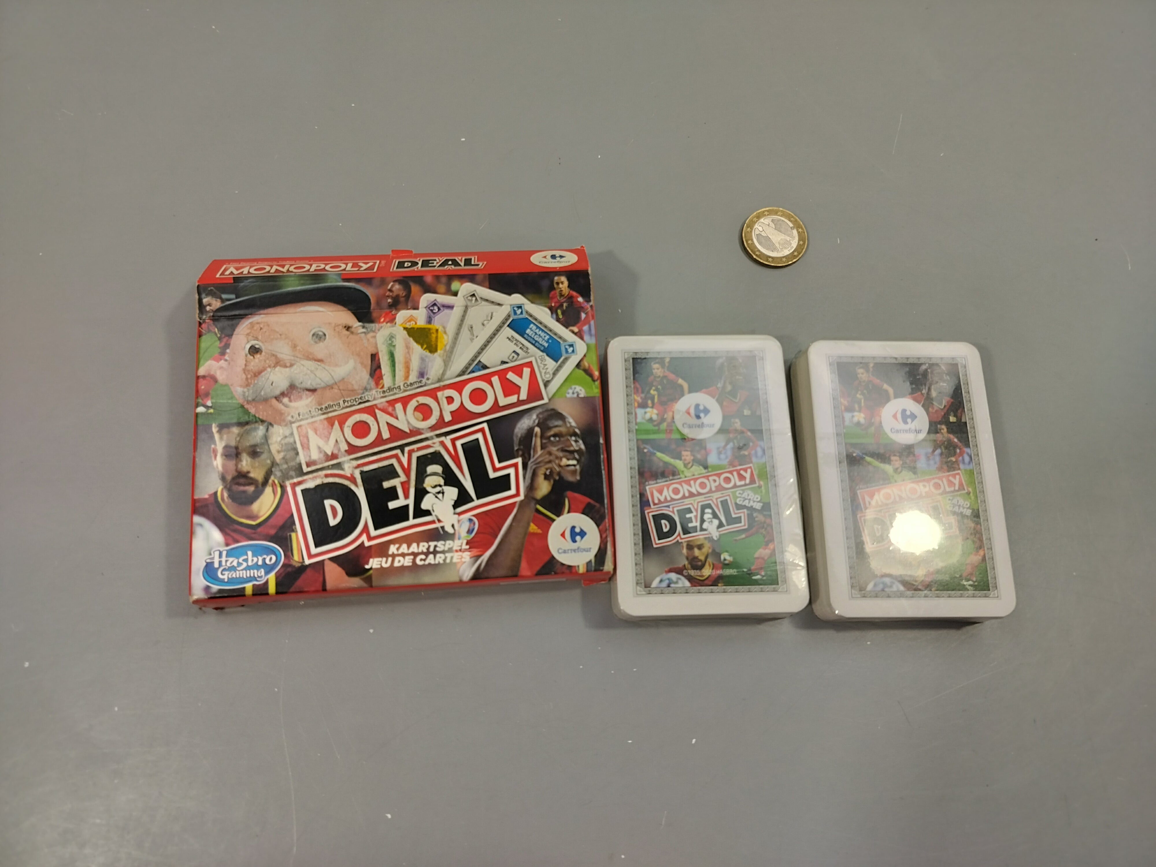 Neuf jeu de carte monopoly deal , diables rouges . Boîte tachée