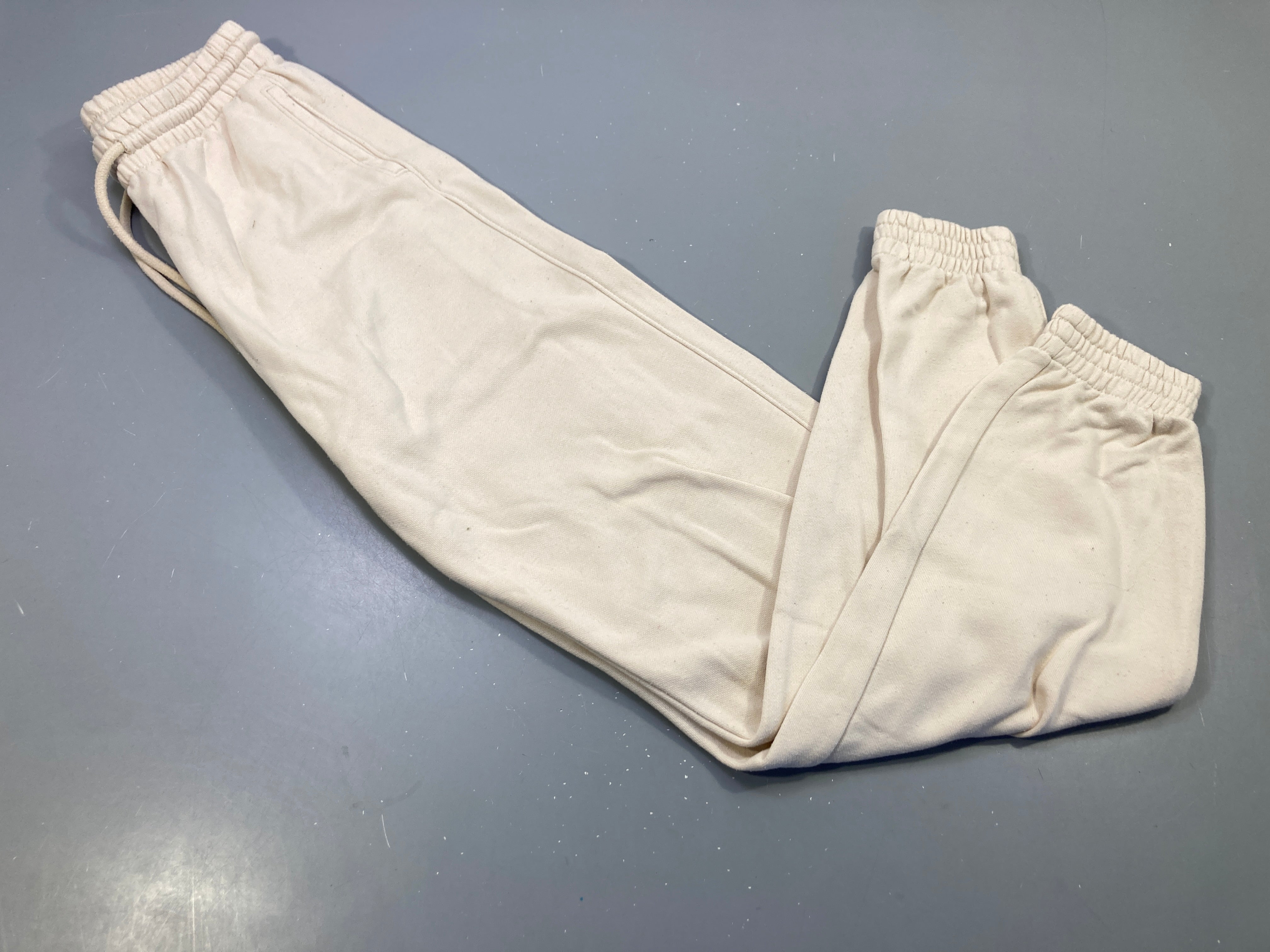 Pantalon jogging beige, taille et chevilles élastiques .  Légèrement bouloché.