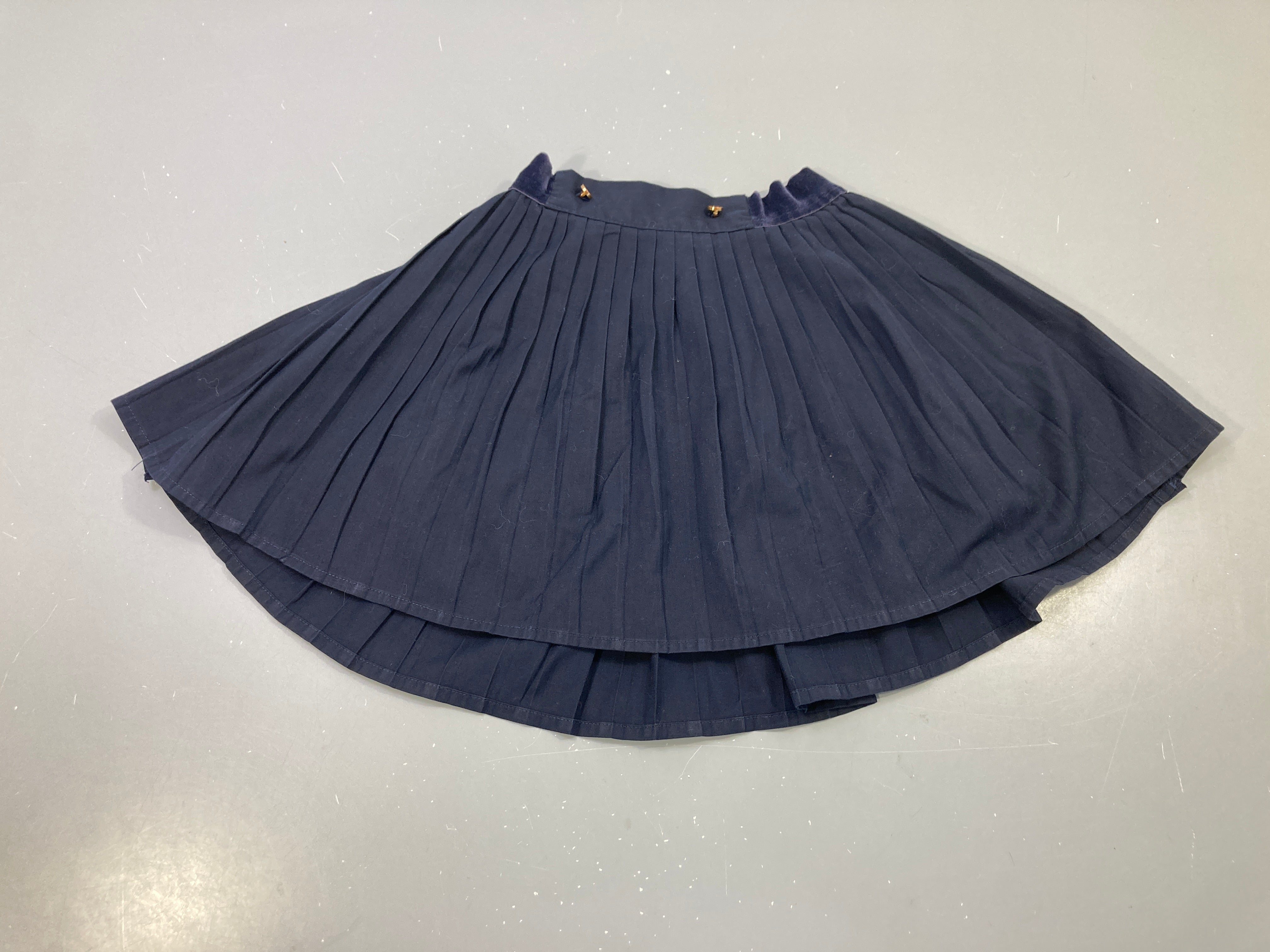 Jupe plissée bleu marine, ceinture velours, boutons dorés