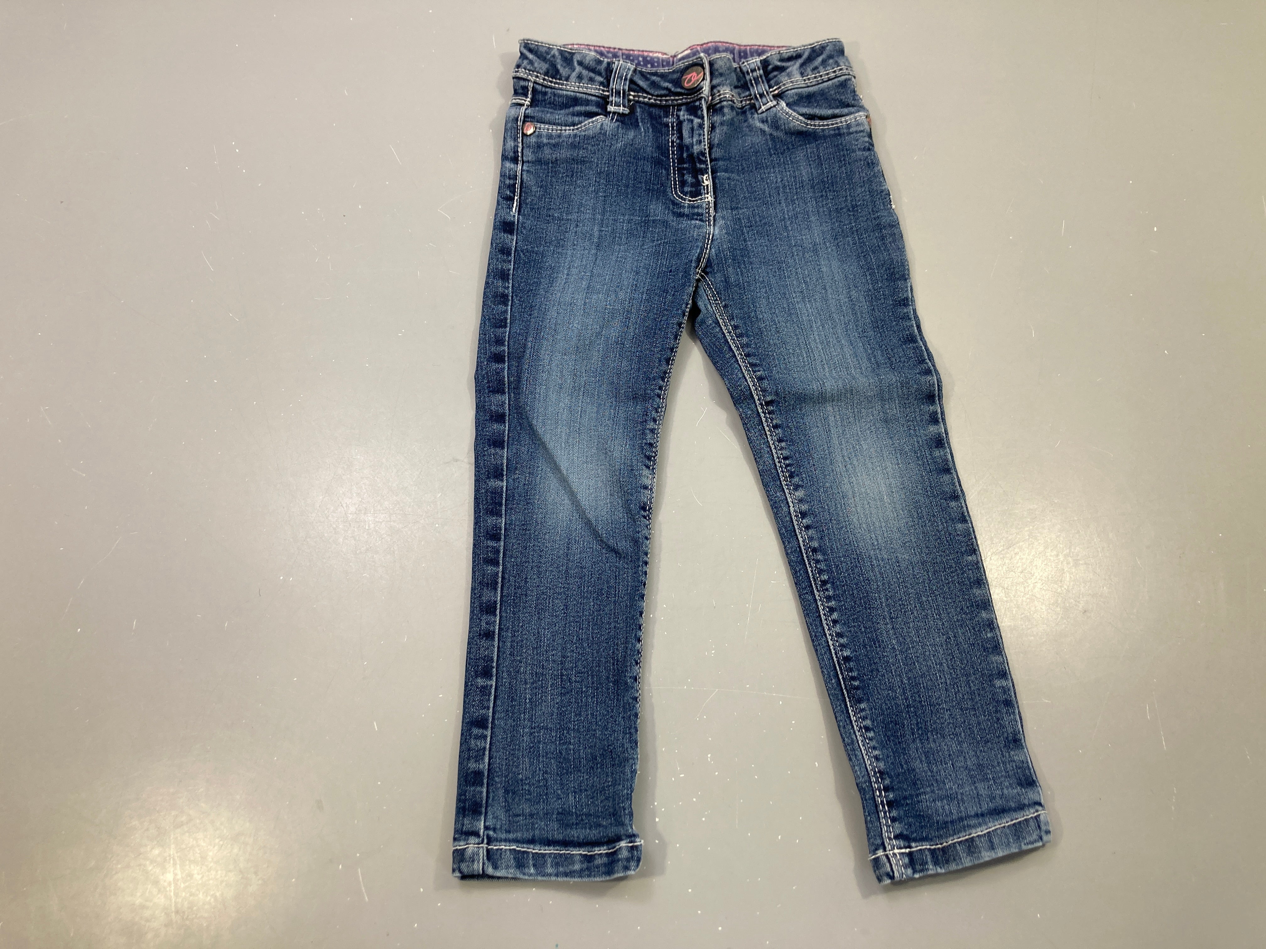 Jeans bleu délavé, surpiqûres blanches, taille réglable