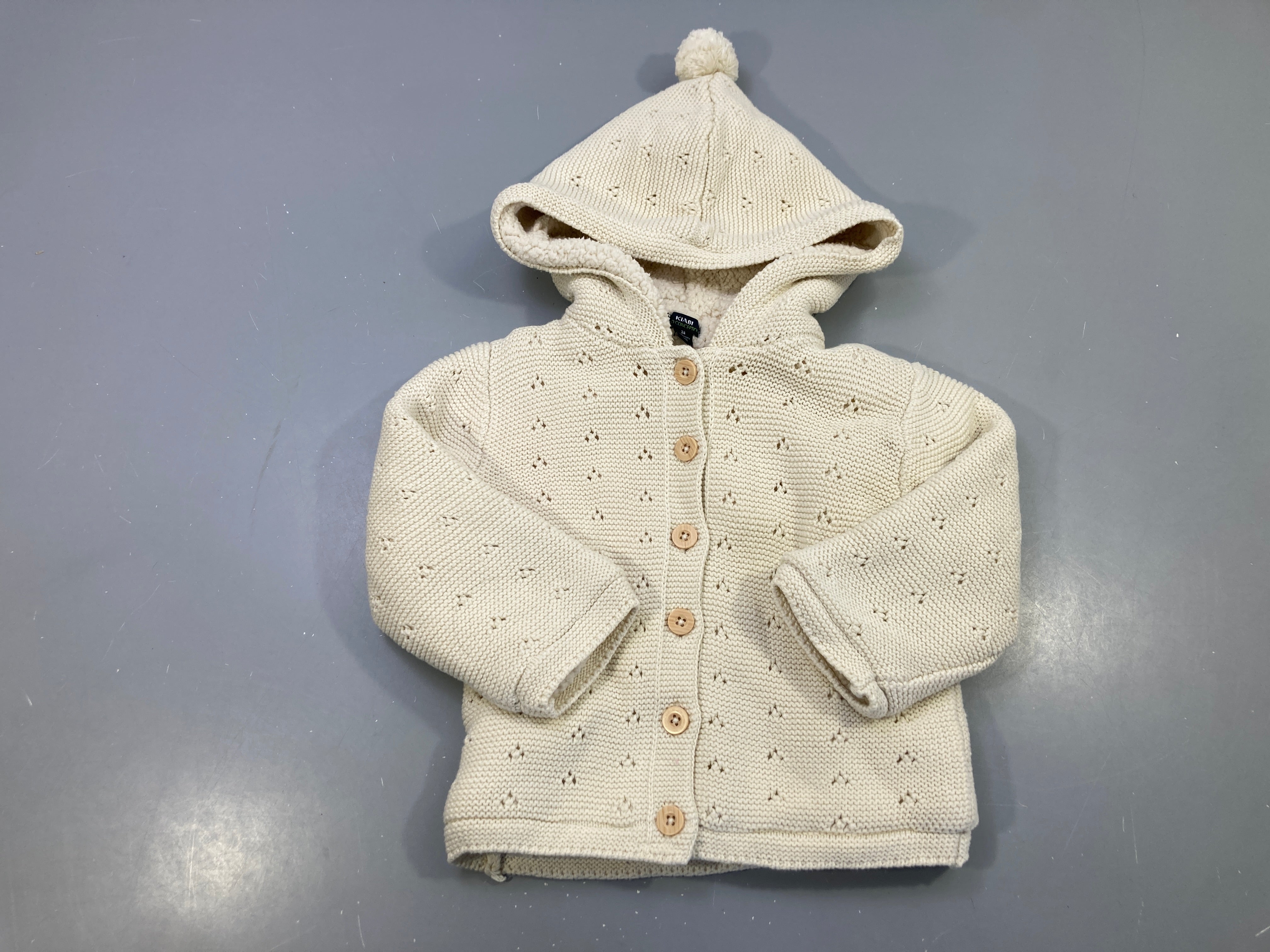 Gilet mailles écru ajouré, doublé peluche à capuche