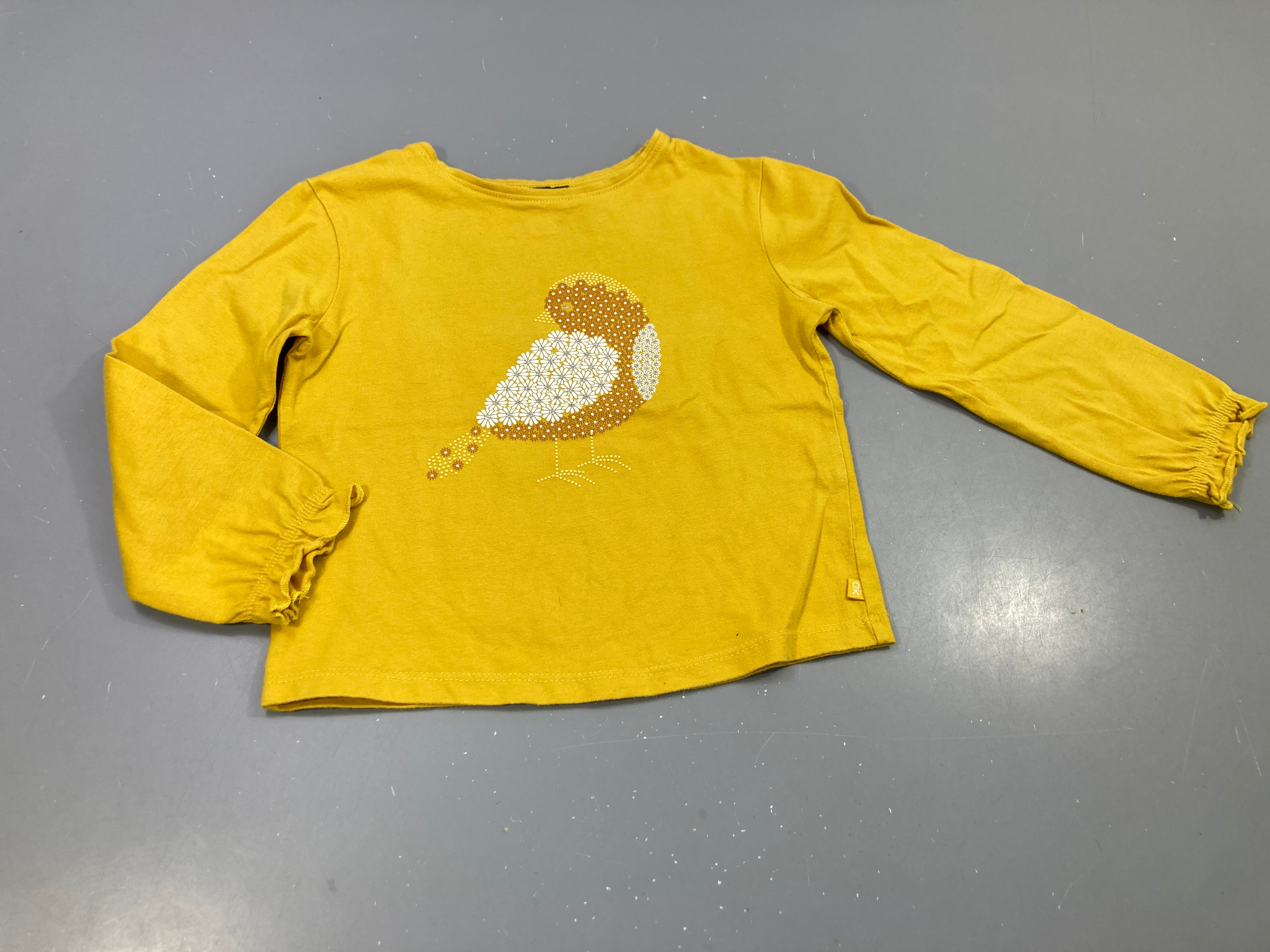 T-shirt m.l jaune , motif oiseau. Poignets élastiqués. Petite tache à l'arrière
