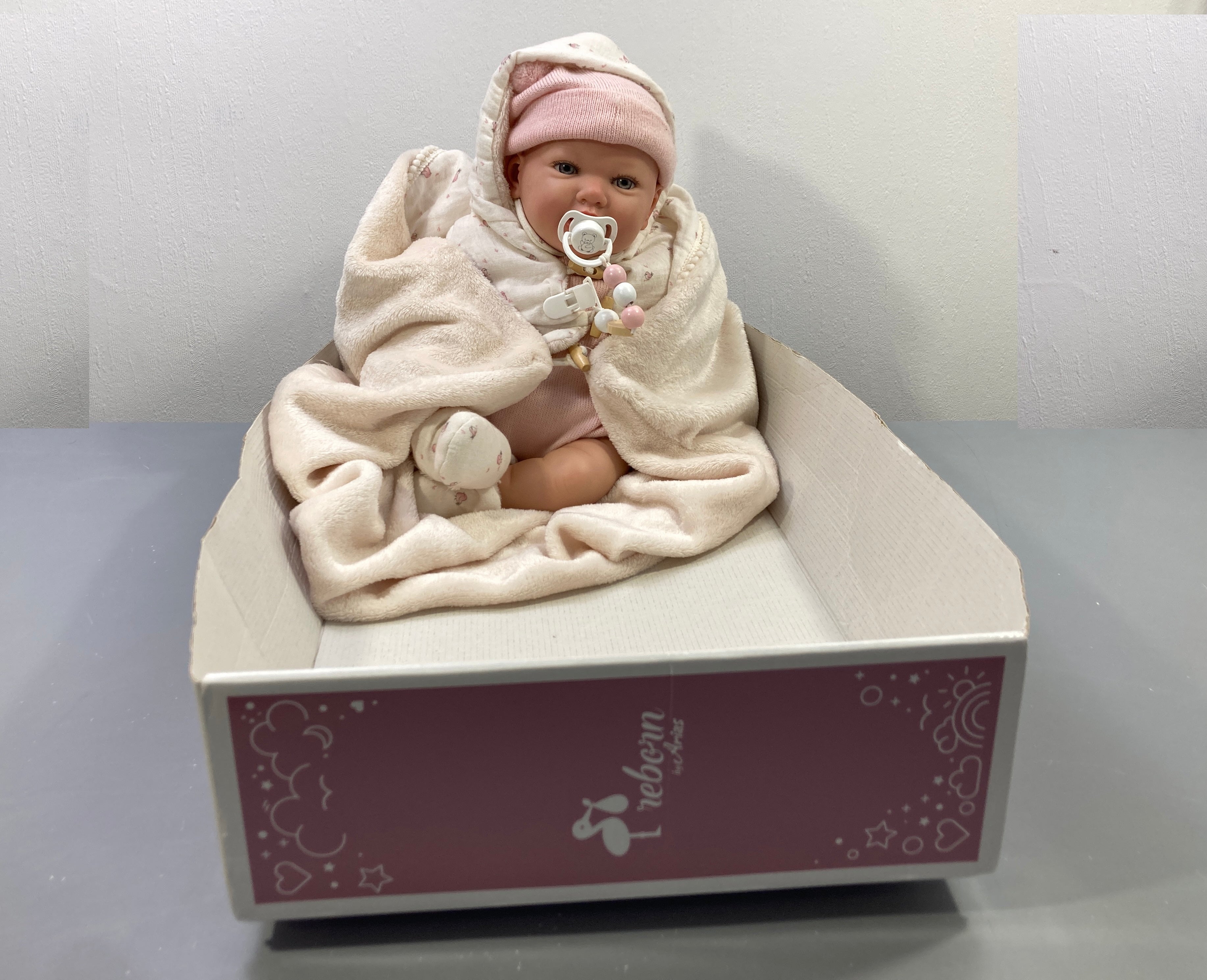 Poupée reborn bonnet rose, couverture écrue, tétine,Reborn, Arias
