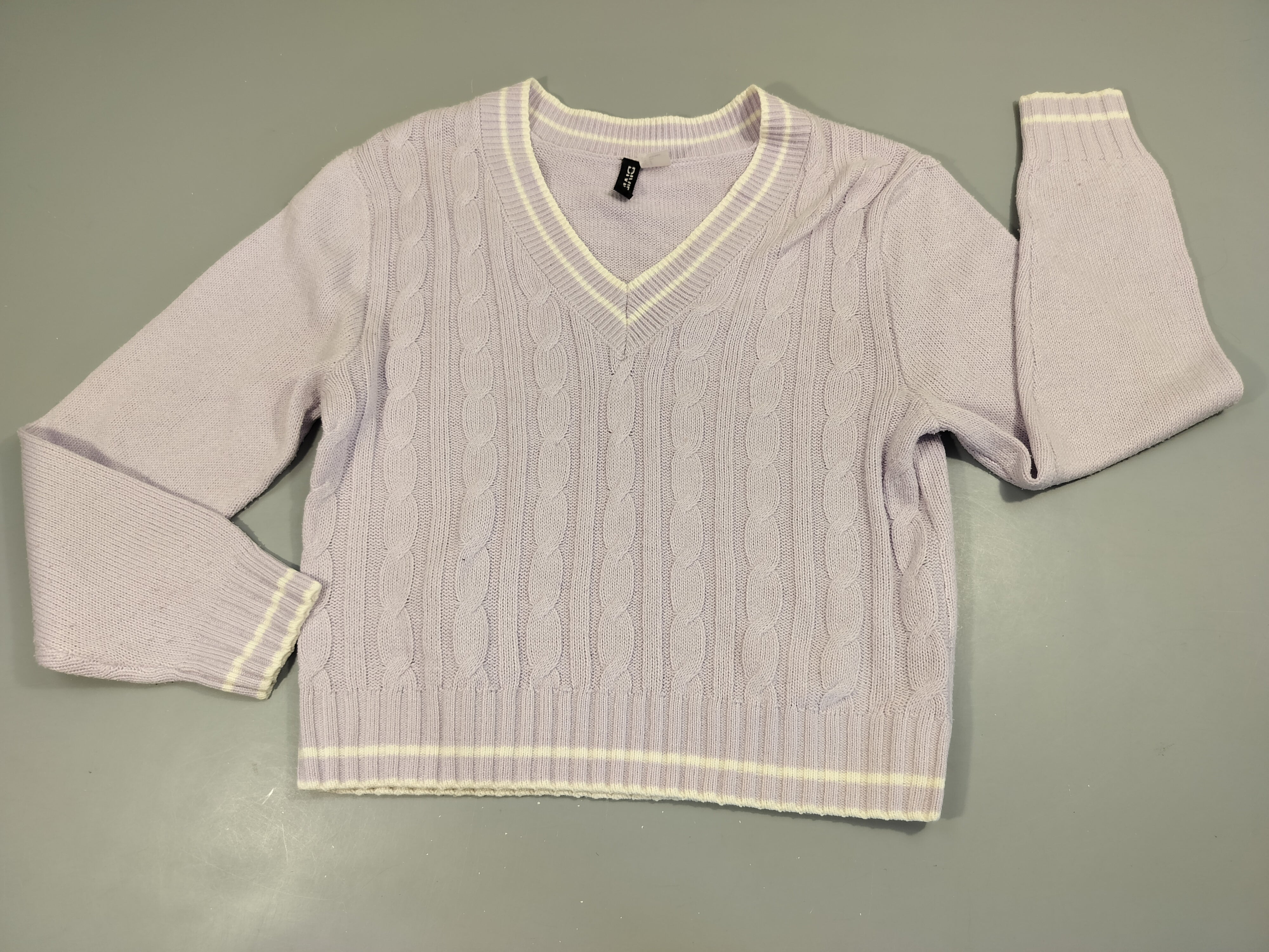 Pull mauve clair torsadé, col V. Légèrement bouloché.