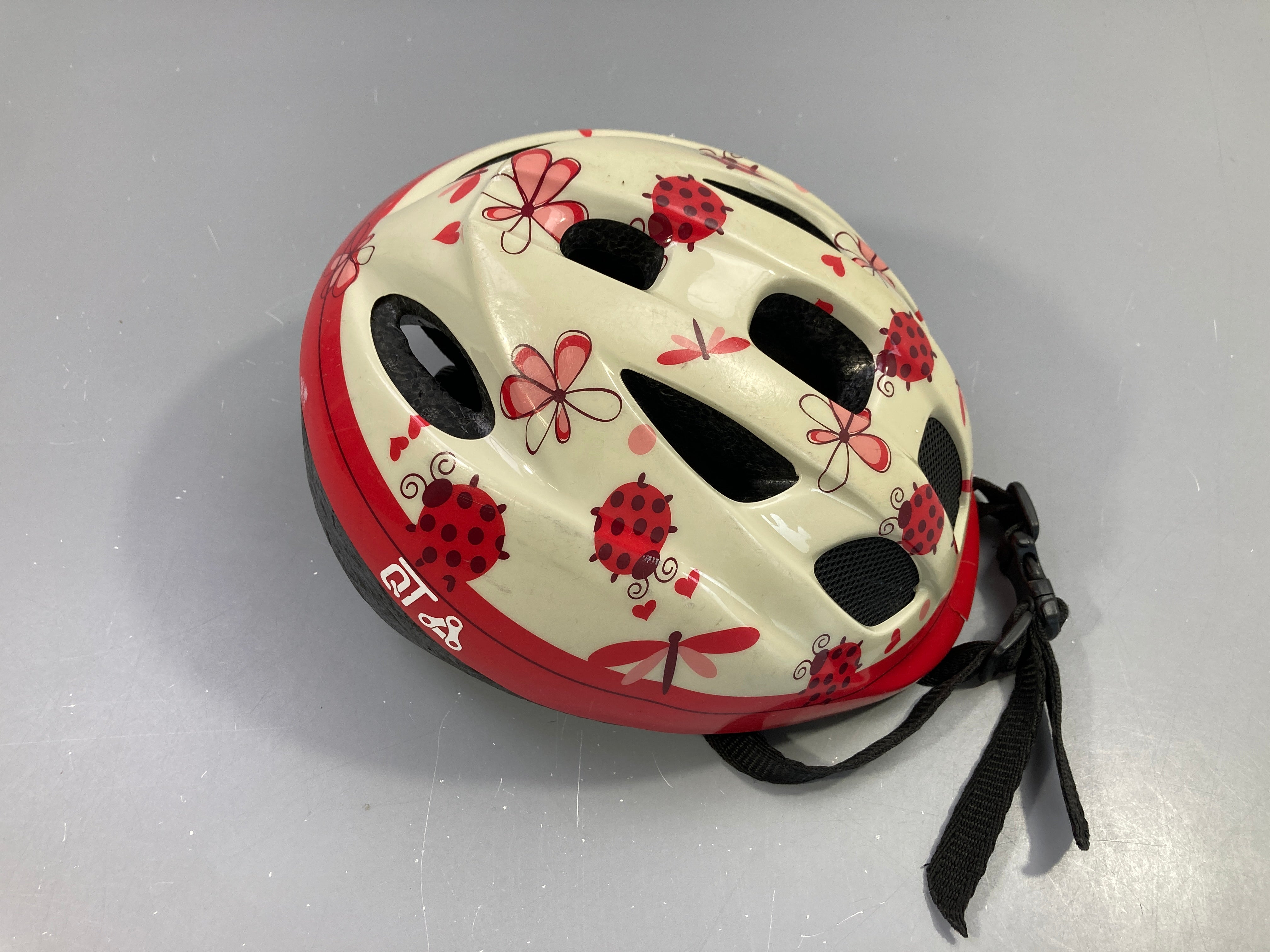 Casque vélo coccinelles-Plastique décoratif un peu fendu coté mais n'engage pas la sécurité