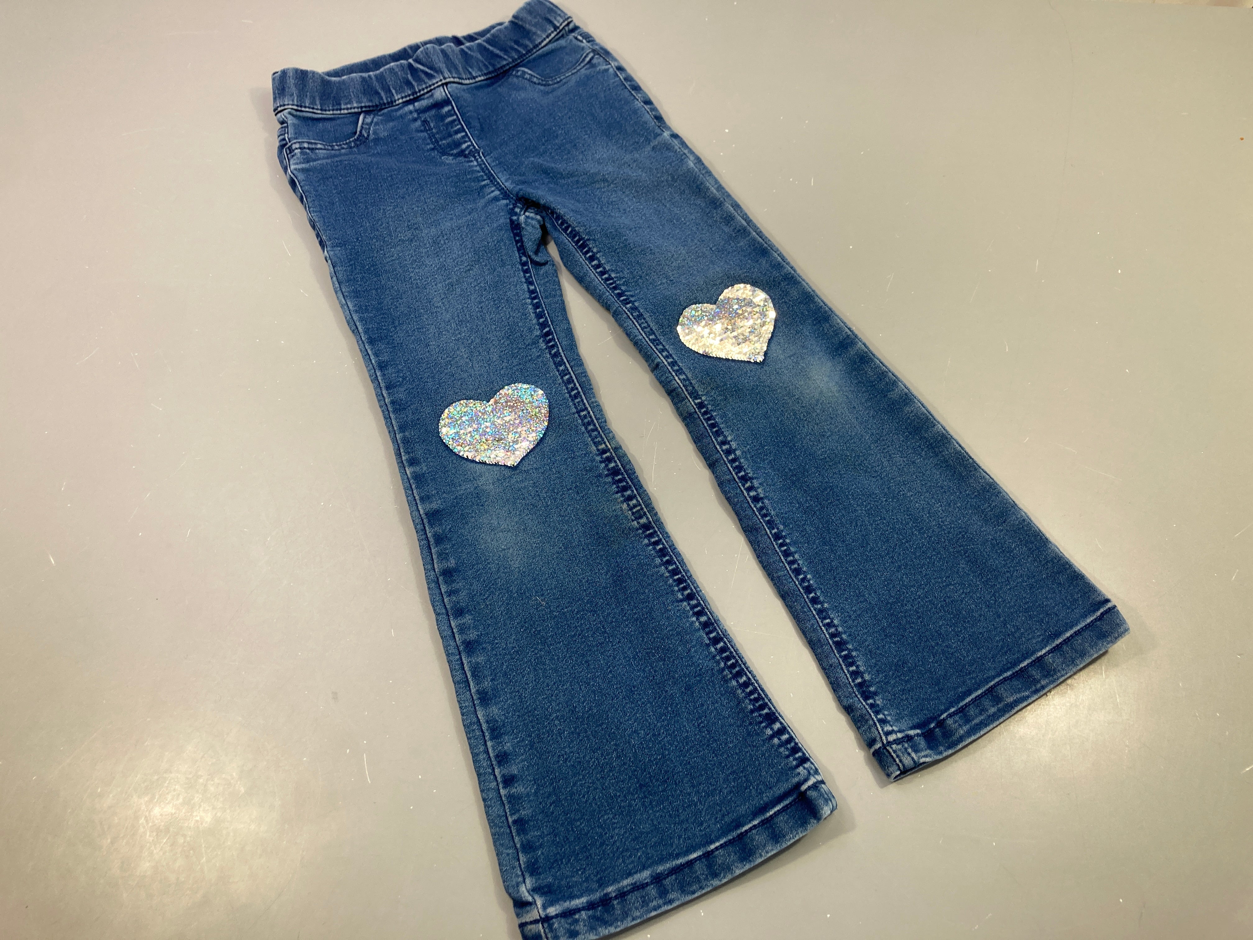 Pantalon denim évasé sur le dessous, coeurs en sequins aux genoux