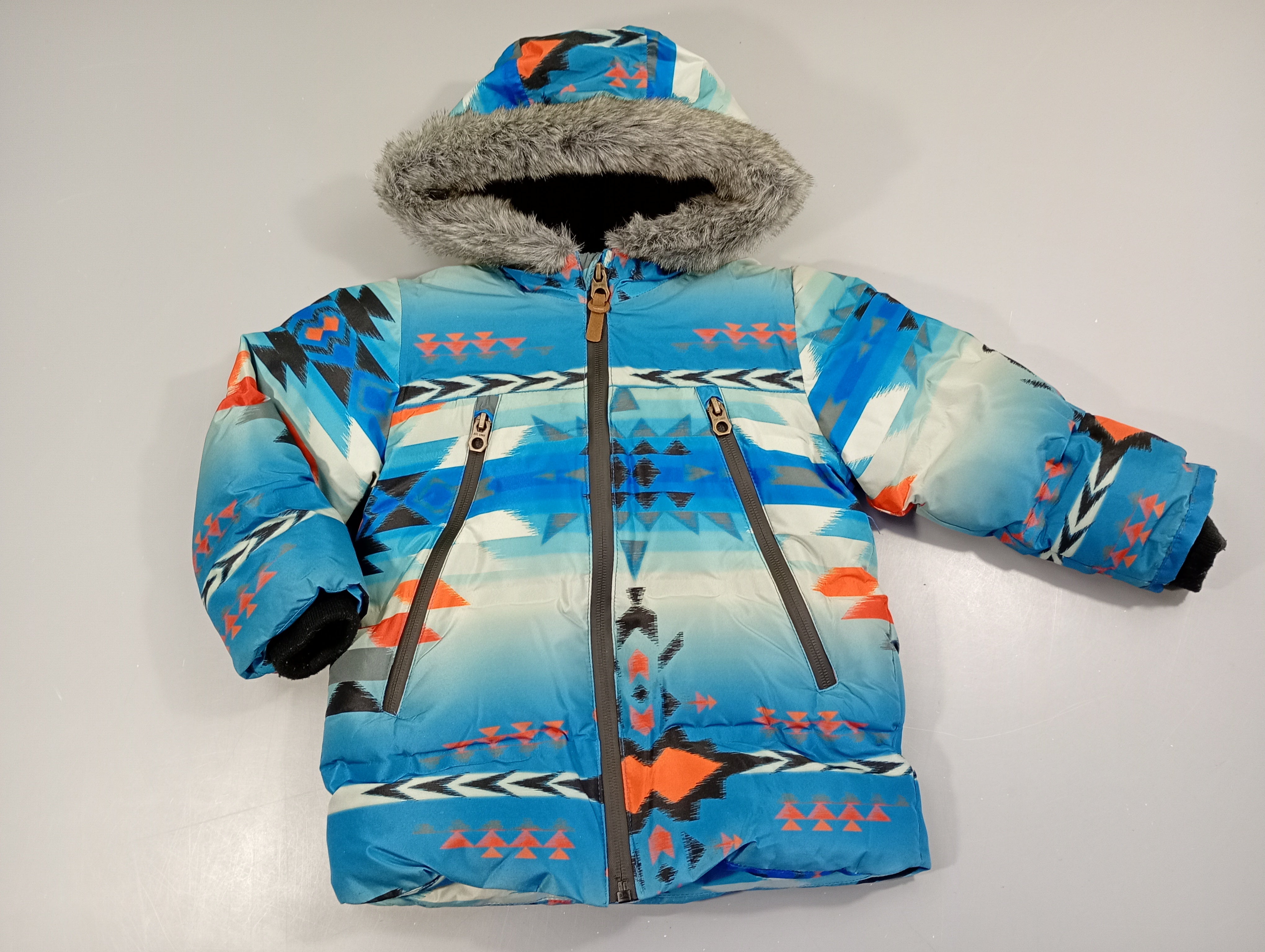 Doudoune zippée bleue imprimés couleurs capuche fausse fourrures .Intérieur polar.  A relaver, petit prix car quelques érafflures